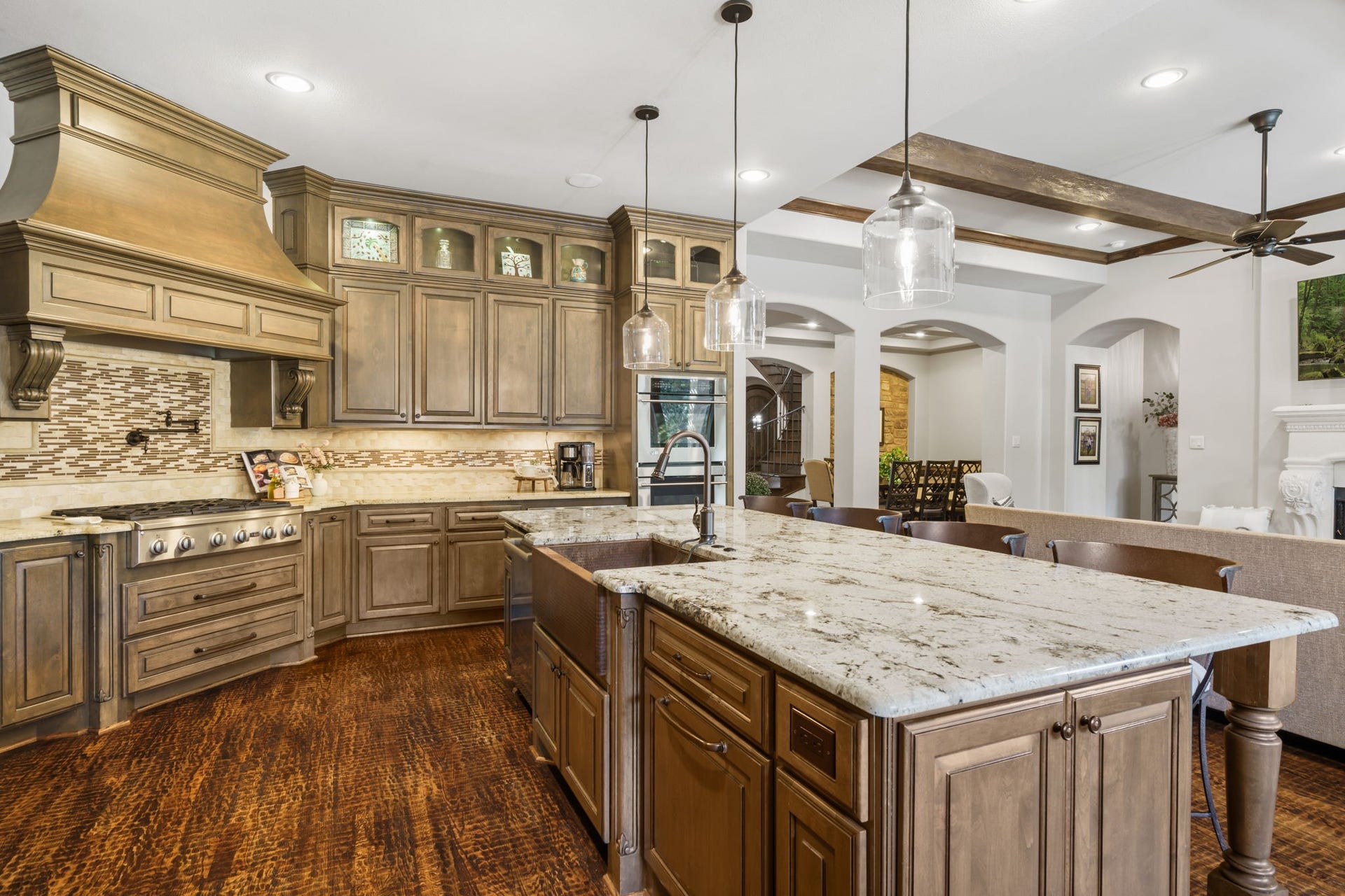 126 Summer Holly Drive, Conroe, TX 77384 Rich cabinetry with glass-front display accents, under-cabinet lighting, and a decorative tile backsplash add warmth and character.