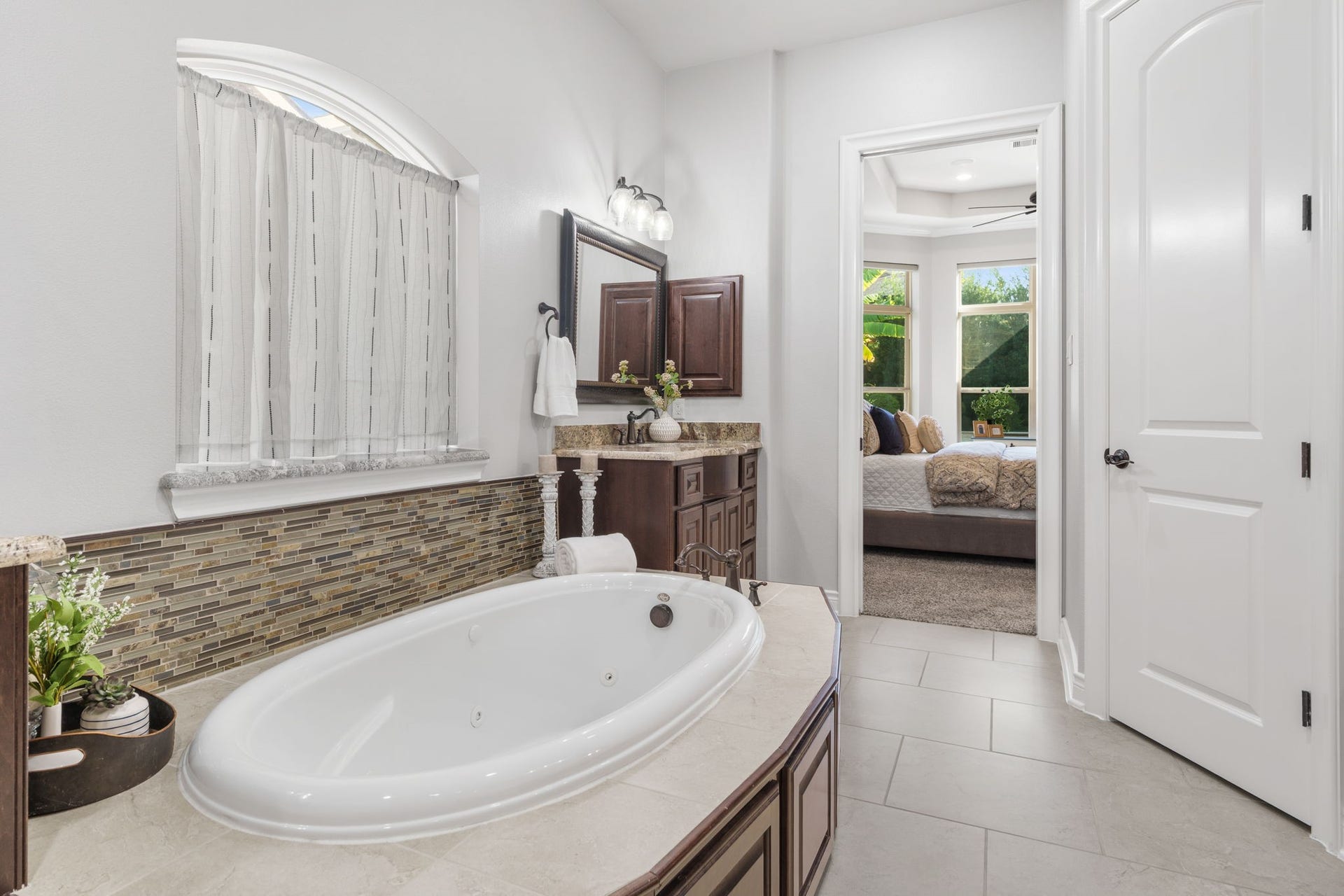 126 Summer Holly Drive, Conroe, TX 77384 Relax in the jetted soaking tub, beautifully accented by decorative mosaic tile and an arched window.