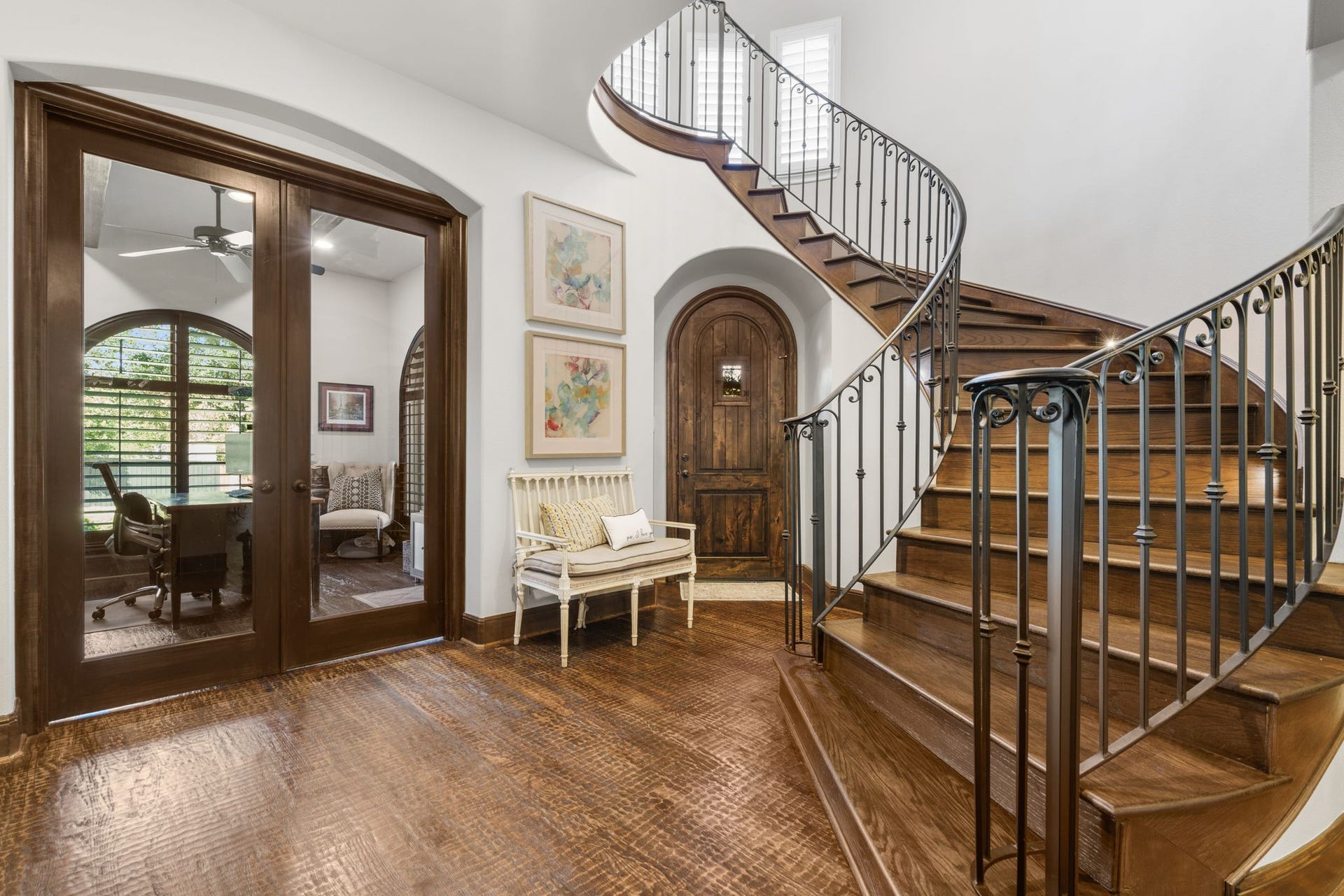 126 Summer Holly Drive, Conroe, TX 77384 Grand entry featuring an elegant curved staircase with wrought-iron railing, beautiful hand-scraped oak floors, and graceful arched doorways.
