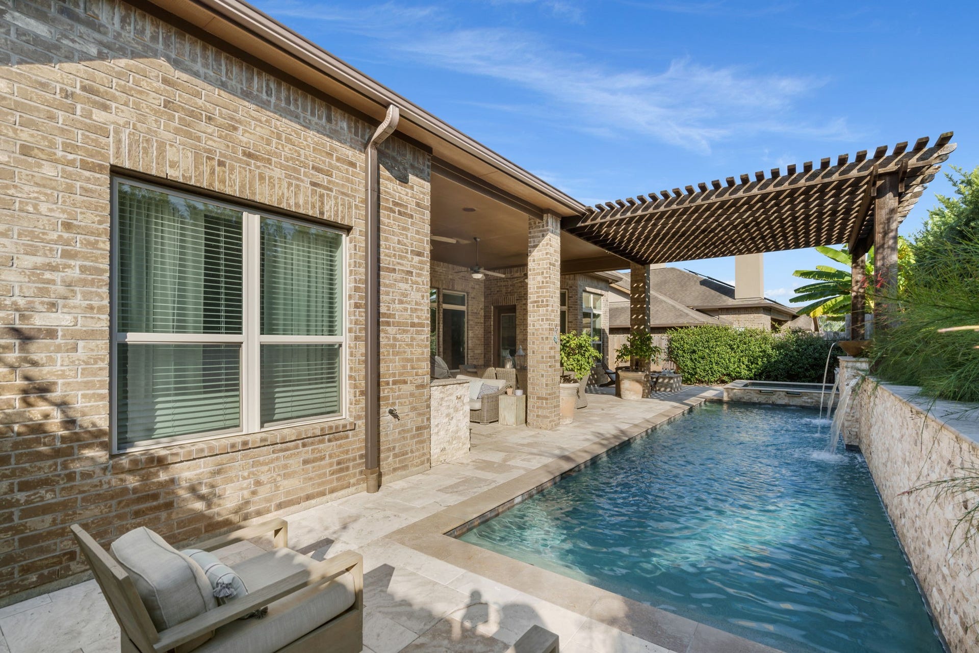 126 Summer Holly Drive, Conroe, TX 77384 Beautiful stone decking and a spacious pergola provide multiple areas to lounge and enjoy the outdoors.