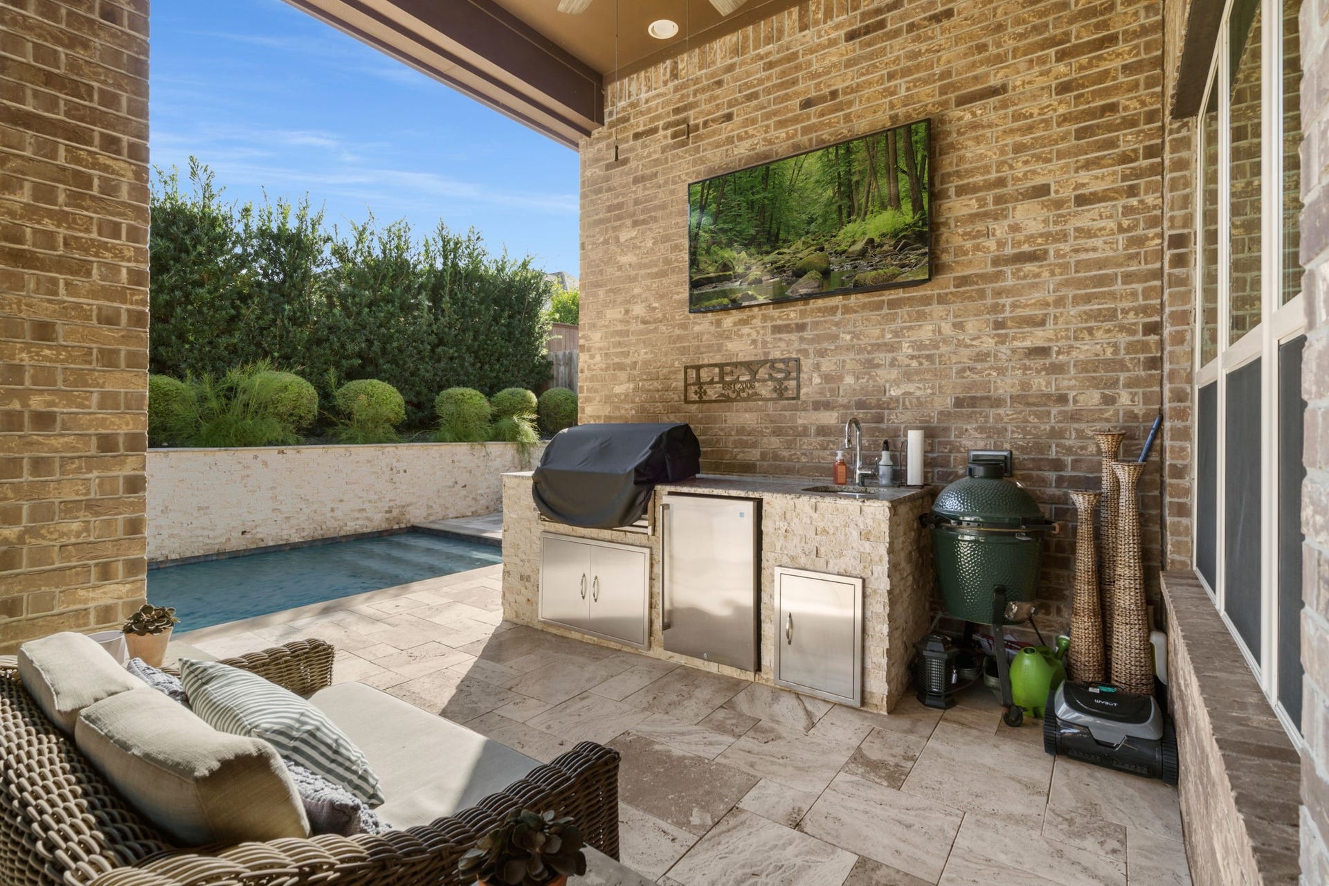 126 Summer Holly Drive, Conroe, TX 77384 Outdoor kitchen features a built-in grill, sink, refrigerator, and stone countertops for year-round entertaining.