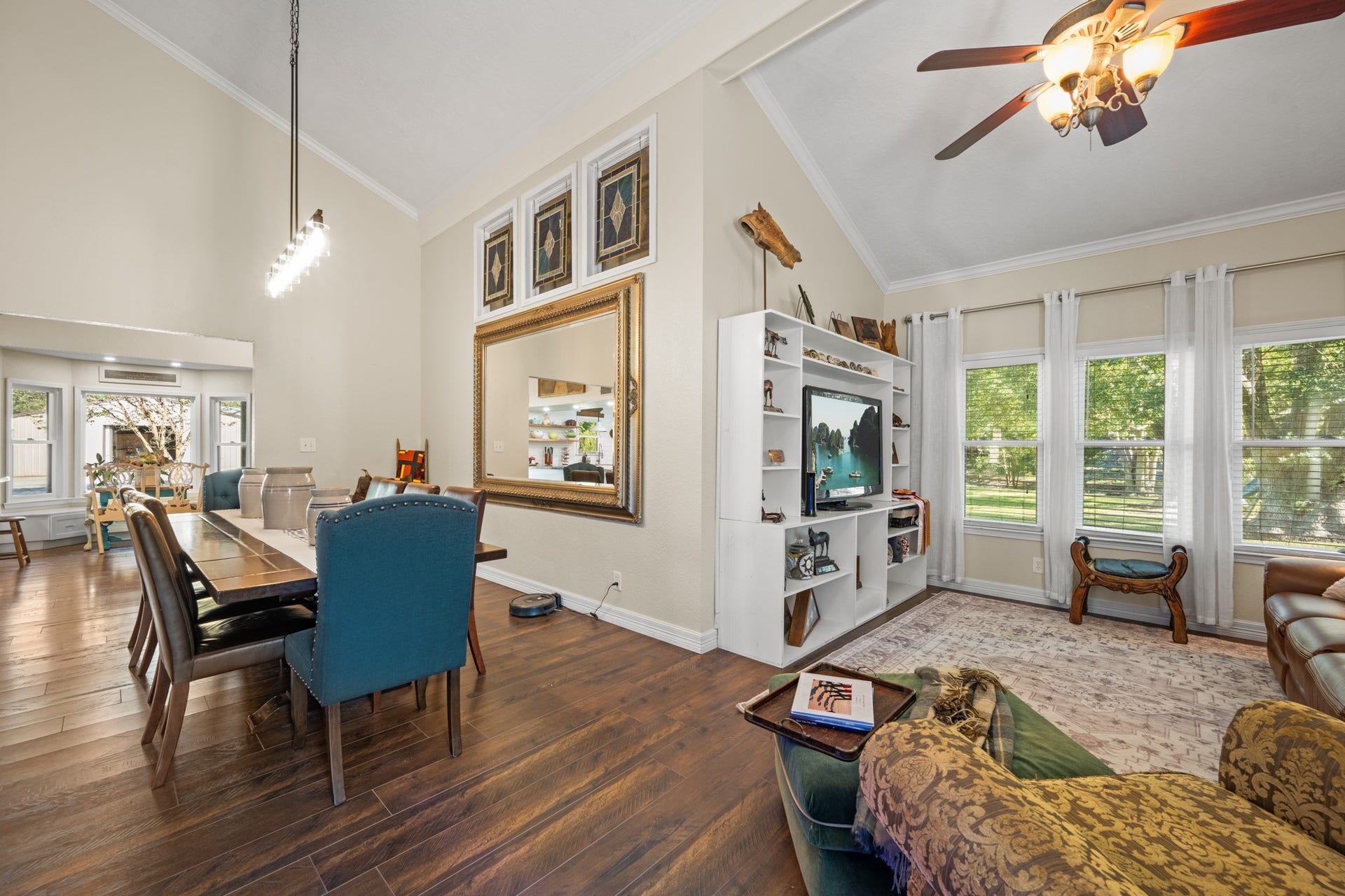 2215 Avenue Q, Santa Fe, TX 77510 An open, flowing layout connects the dining area and family room, enhanced by high ceilings, abundant natural light, and expansive windows overlooking the property's greenery.