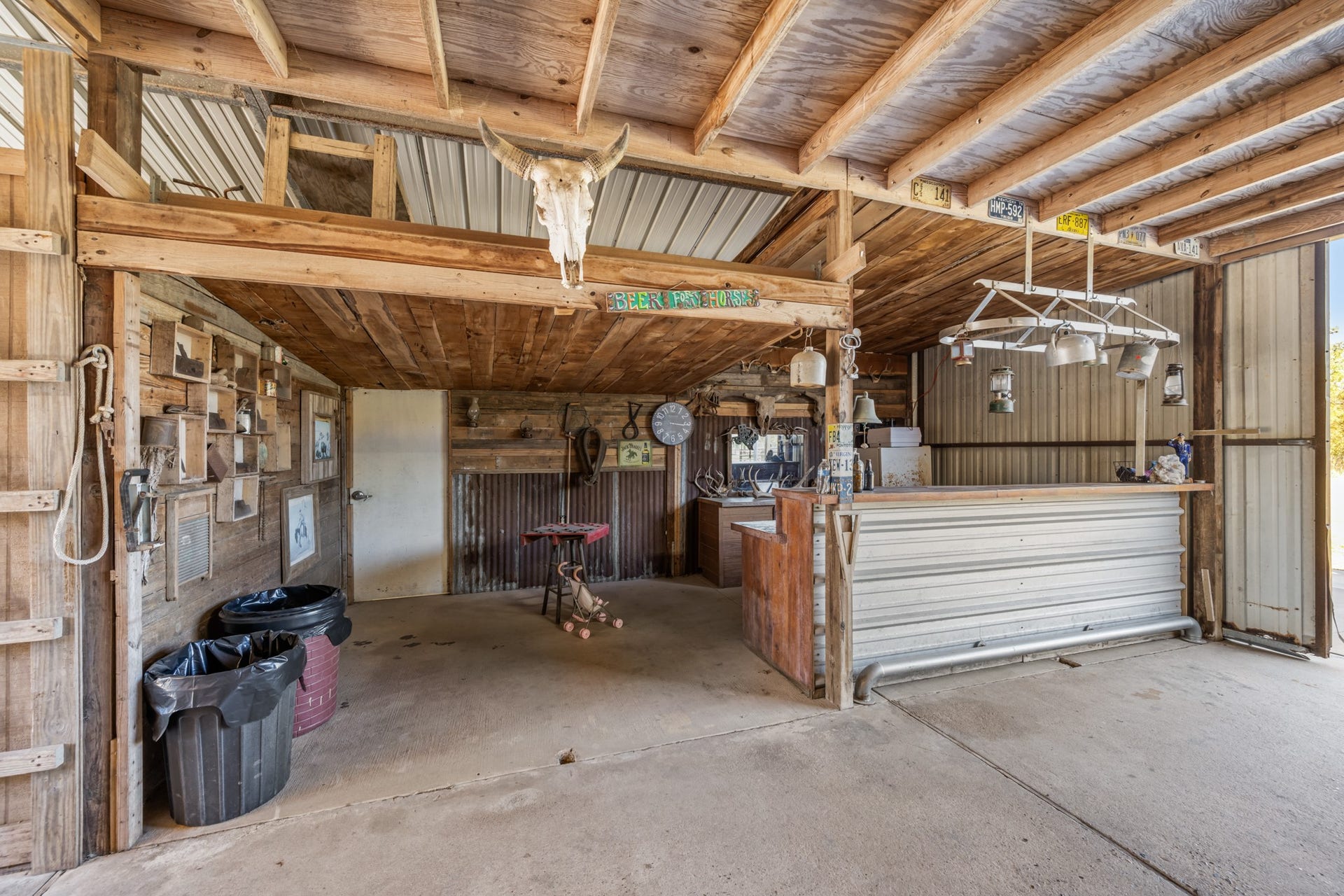 2215 Avenue Q, Santa Fe, TX 77510 Bring your friends together in this one-of-a-kind rustic gathering space featuring a Western-inspired bar, corrugated metal accents, exposed wood beams, decorative lighting, and overhead loft.