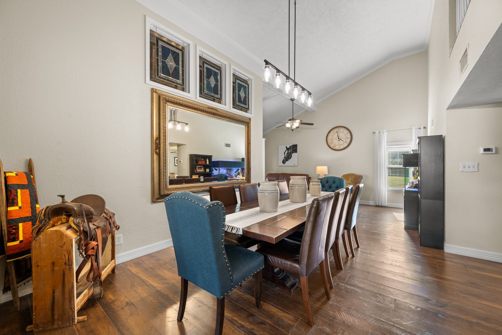 2215 Avenue Q, Santa Fe, TX 77510 Spacious formal dining area features soaring ceilings, decorative stained-glass accent windows, elegant pendant lighting, and warm wood-look flooring, offering plenty of room for gatherings and entertaining.