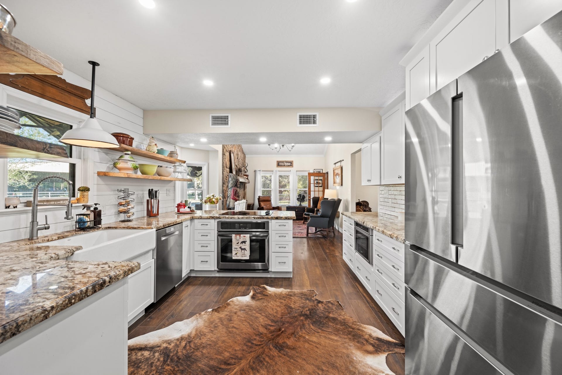2215 Avenue Q, Santa Fe, TX 77510 A spacious, thoughtfully designed kitchen features stainless steel appliances, abundant cabinetry, granite countertops, and an open connection to the living area.
