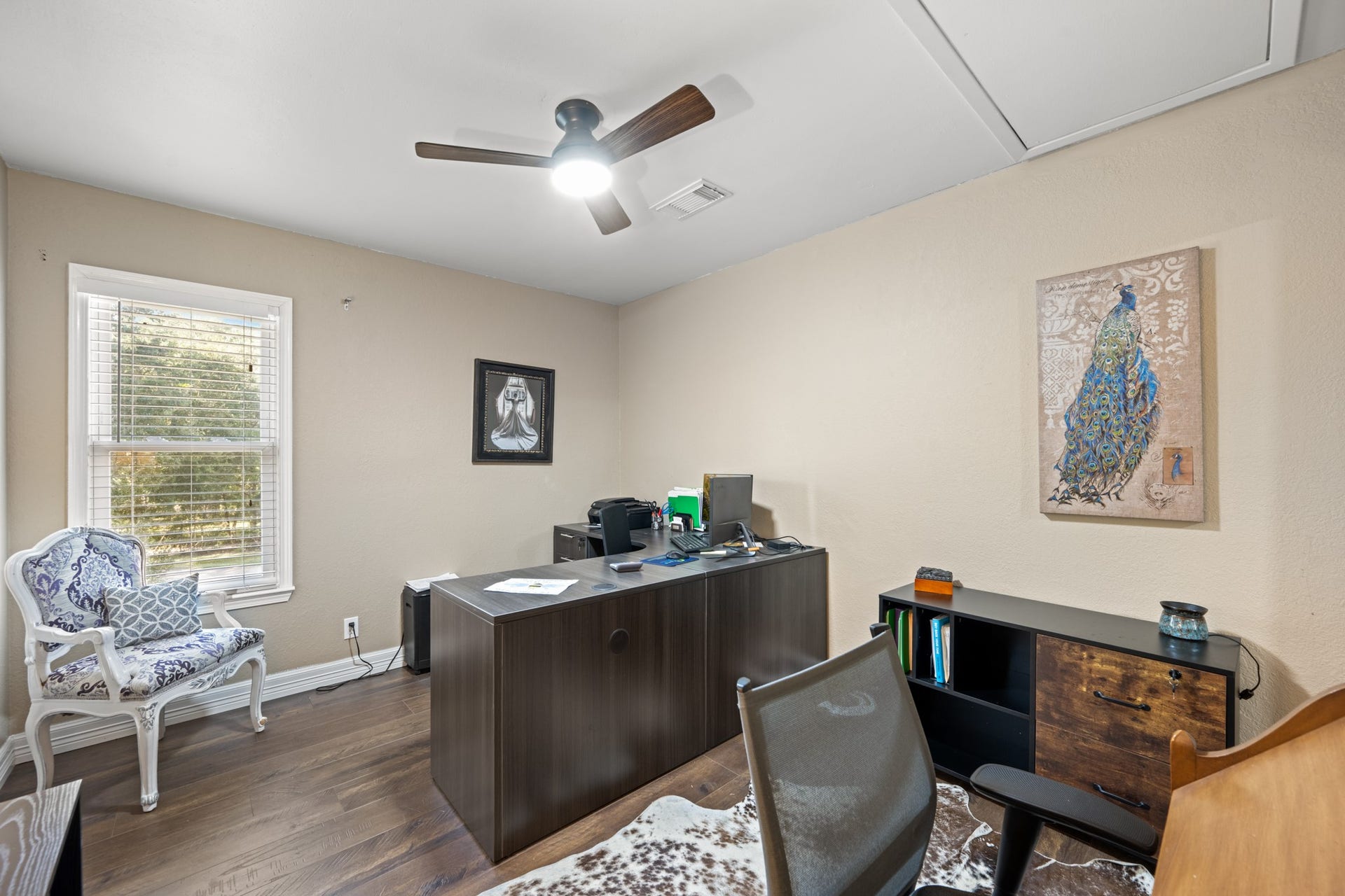 2215 Avenue Q, Santa Fe, TX 77510 Versatile bedroom currently configured as a home office, featuring wood-look flooring, neutral tones, a ceiling fan, and a window providing natural light. Easily adaptable as an additional bedroom, study, or creative workspace to suit your needs.