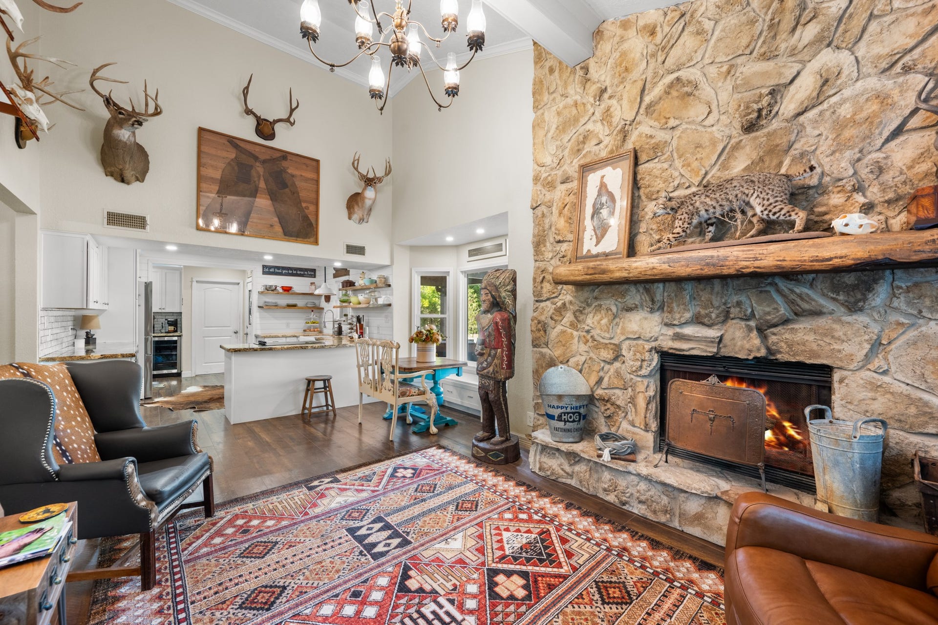 2215 Avenue Q, Santa Fe, TX 77510 An impressive stone fireplace and vaulted ceilings create a striking focal point, while the open layout connects the living room to the farmhouse-style kitchen and breakfast nook.