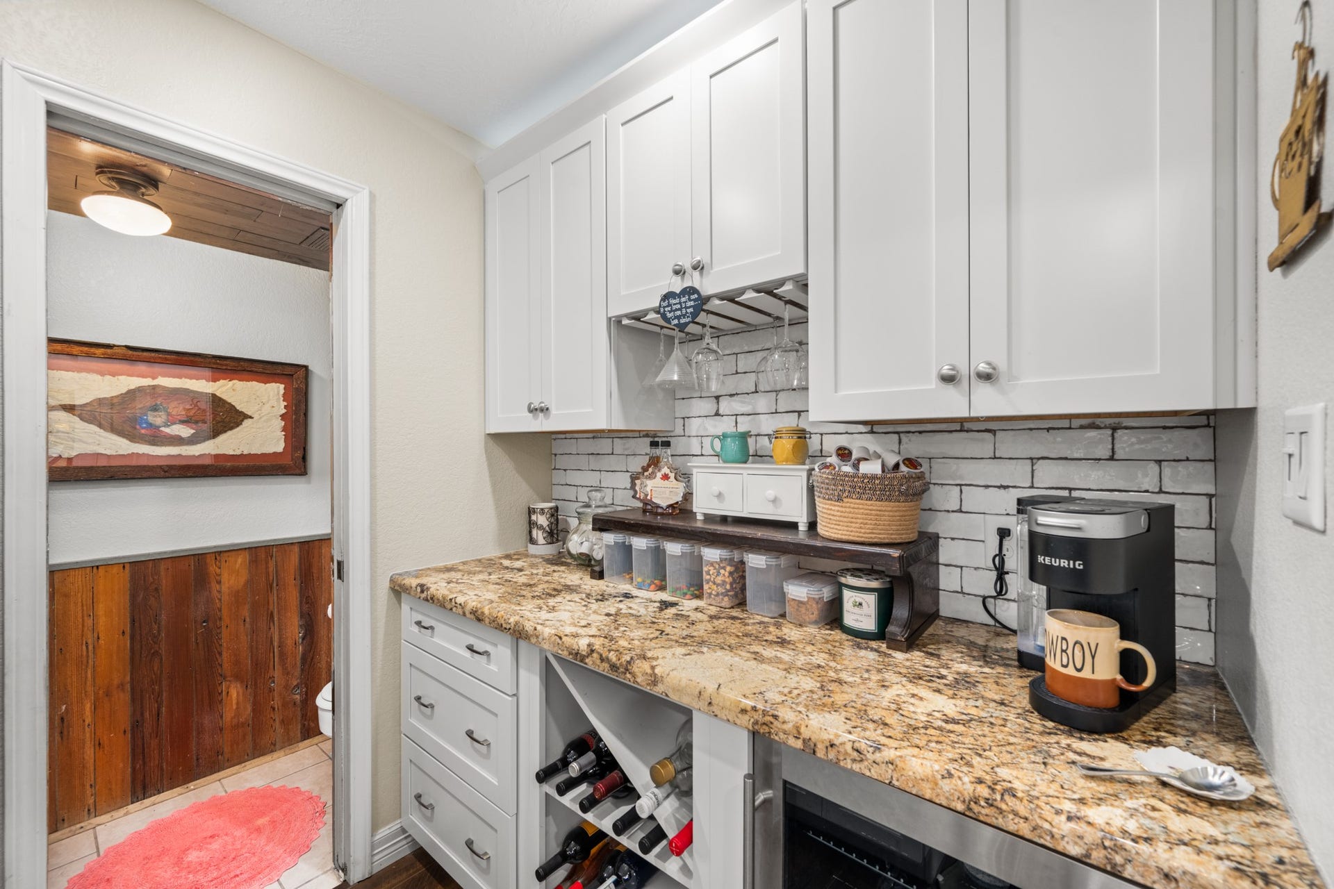 2215 Avenue Q, Santa Fe, TX 77510 A dedicated coffee and beverage station/butlers pantry offers granite countertops, custom-style cabinetry, built-in wine storage, hanging stemware racks, and an undercounter beverage refrigerator.