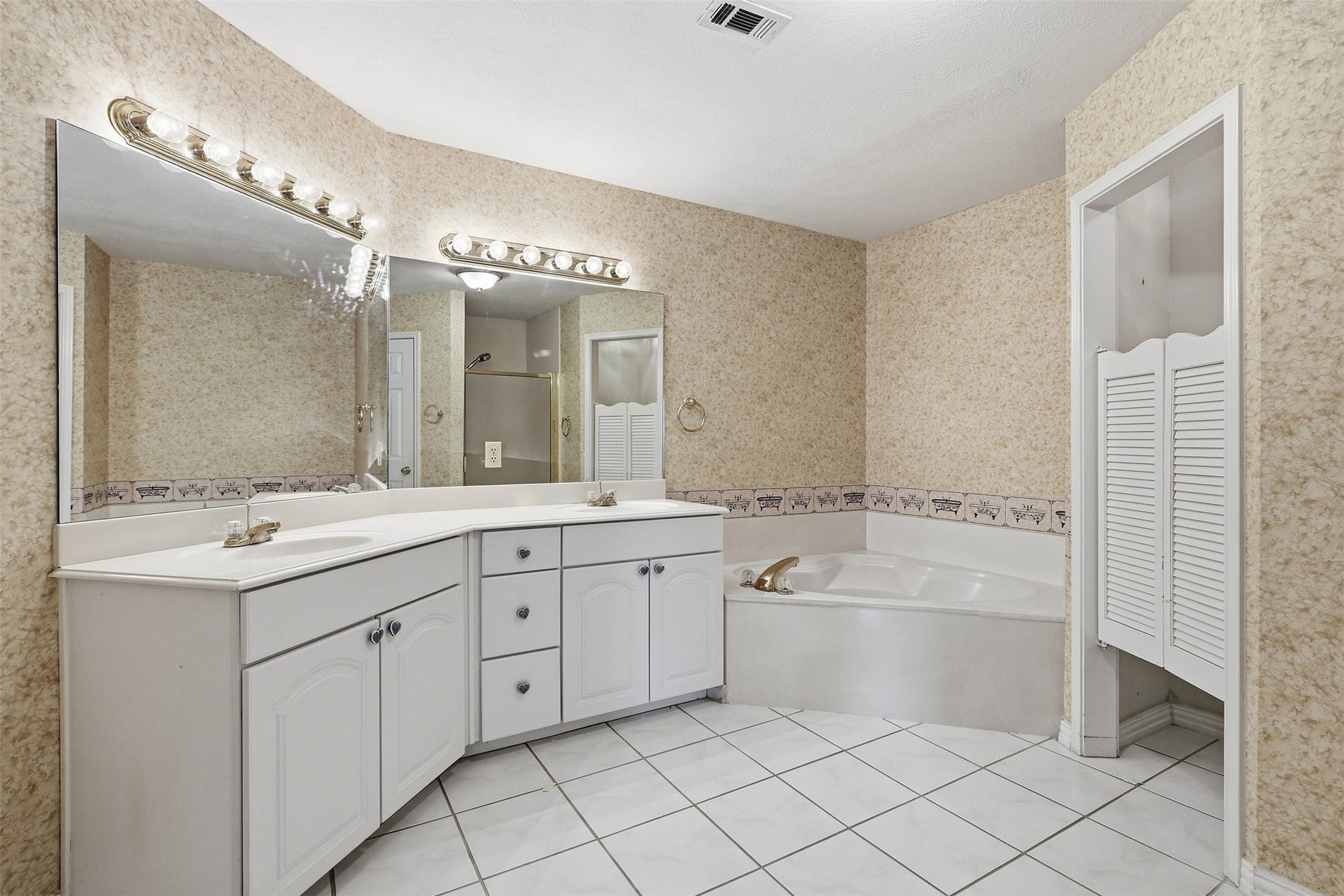 10707 Crestfield Court, Houston, TX 77070 well-appointed en-suite bath featuring dual vanities, soaking tub, and separate shower