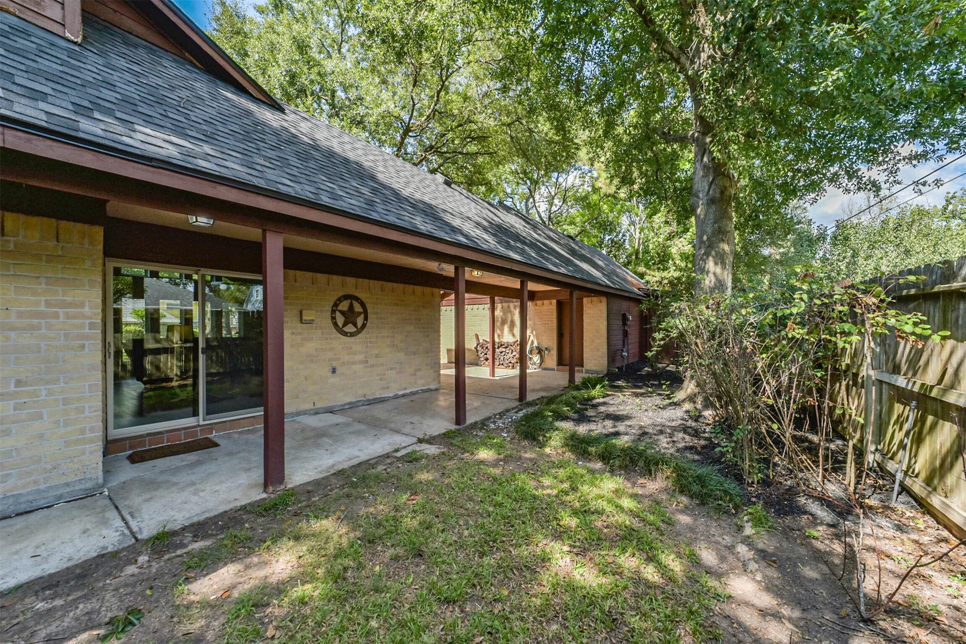 7618 Hurst Forest Drive, Humble, TX 77346 Large windows overlook the covered patio and wooded yard, bringing the outdoor setting into everyday life. The long shaded porch offers a welcoming spot to unwind or gather with friends.