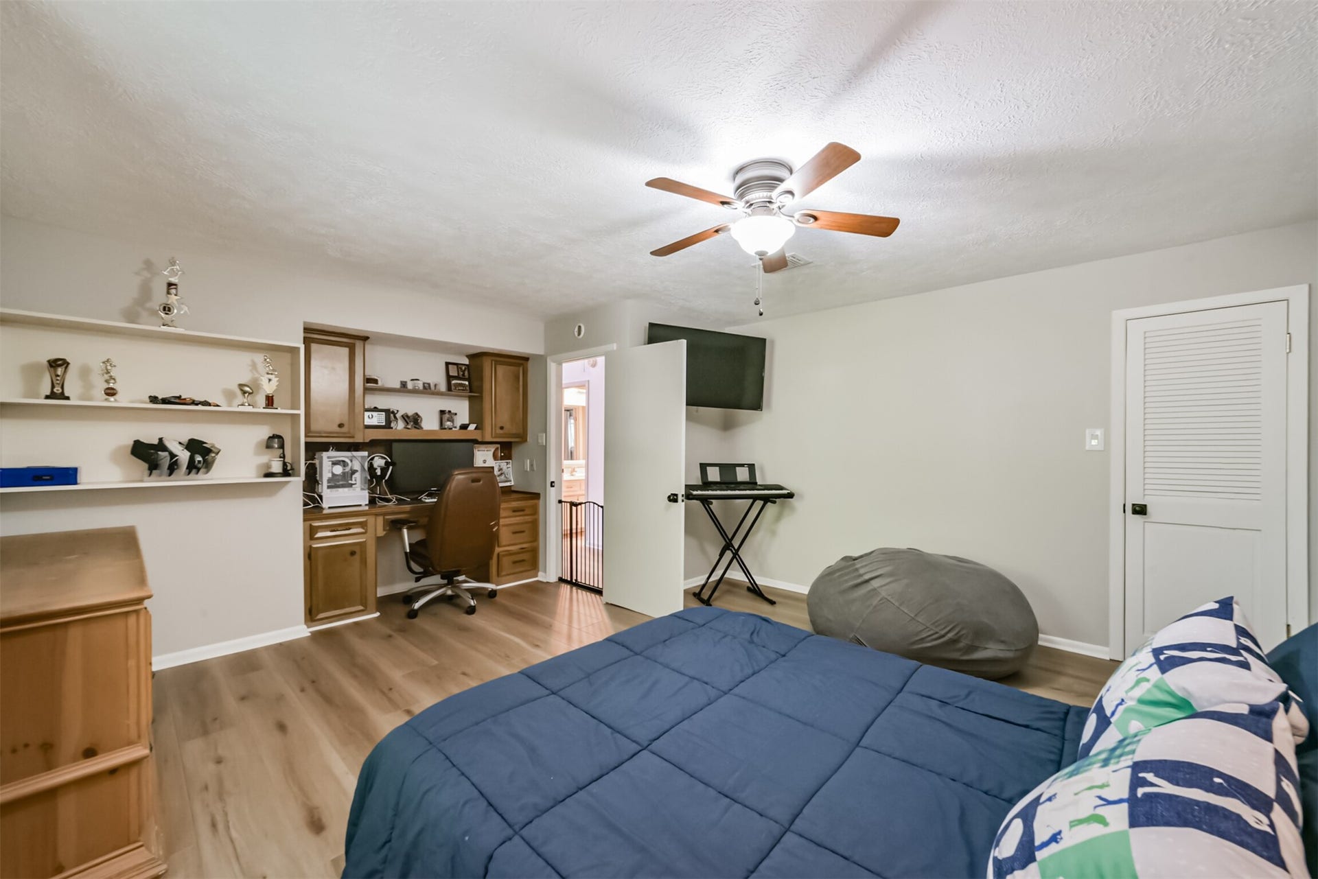 7618 Hurst Forest Drive, Humble, TX 77346 A built-in desk and surrounding storage give this bedroom a convenient workspace without sacrificing room to relax. Open shelving keeps books and favorite pieces close at hand, creating a practical setting for study or creative projects.