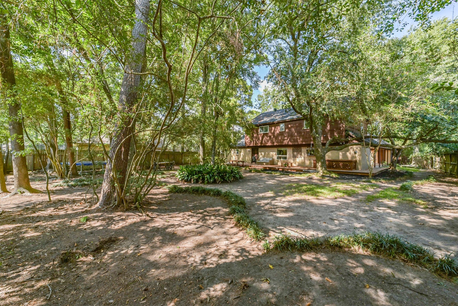 7618 Hurst Forest Drive, Humble, TX 77346 This wider backyard view showcases a wooded setting with space to explore your outdoor vision. The deck anchors the gathering area, while the surrounding trees create a feeling of retreat just beyond the back door.