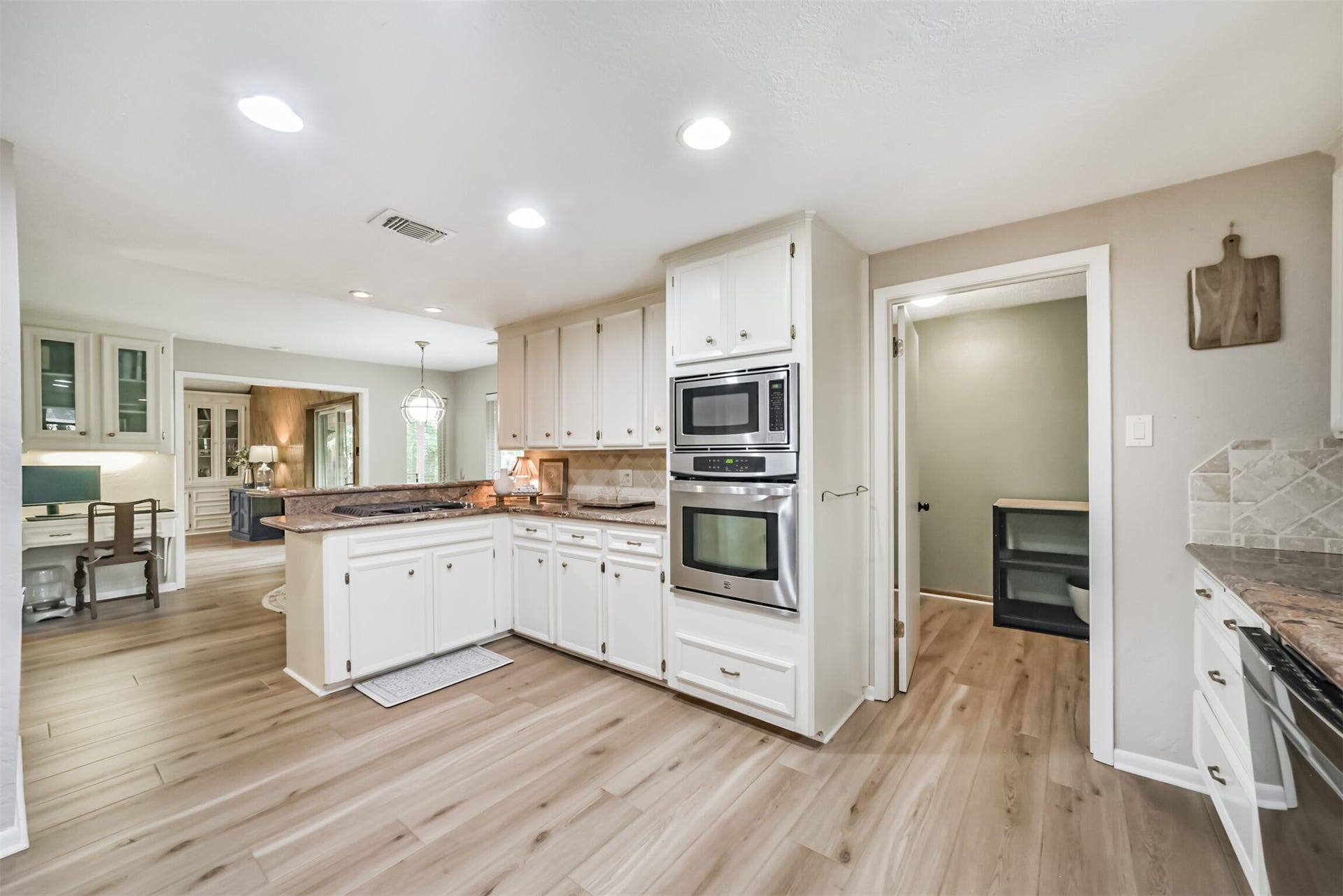 7618 Hurst Forest Drive, Humble, TX 77346 A built-in oven and microwave help keep counters clear, while the peninsula offers a convenient spot to serve meals. Easy access to the adjoining dining area and utility room adds practical flow to daily routines.