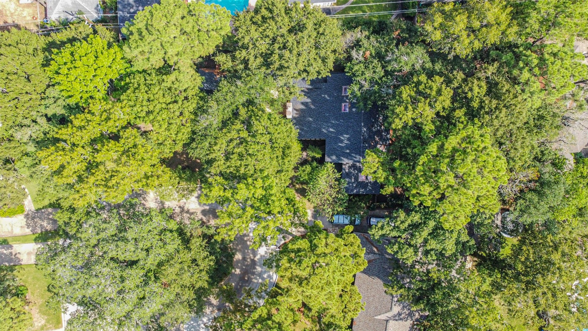 7618 Hurst Forest Drive, Humble, TX 77346 An overhead perspective highlights the homes wooded surroundings, with greenery framing the roofline and outdoor spaces. Enjoy a setting that feels connected to nature from the moment you arrive.