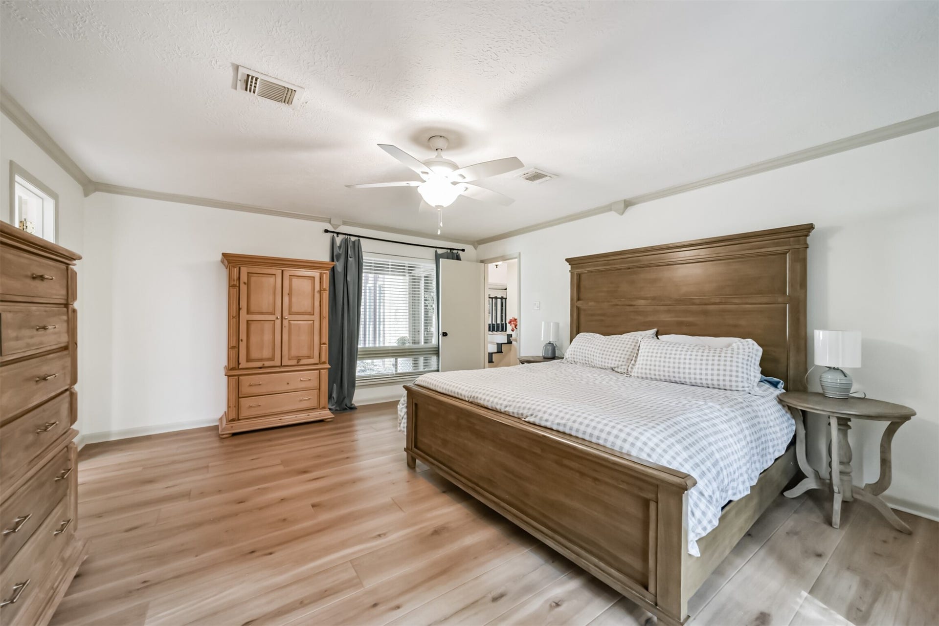 7618 Hurst Forest Drive, Humble, TX 77346 A generous bedroom layout offers comfortable space for a large bed, nightstands, and additional furnishings. Warm wood-look flooring and soft neutral walls create a restful retreat ready for your personal style.