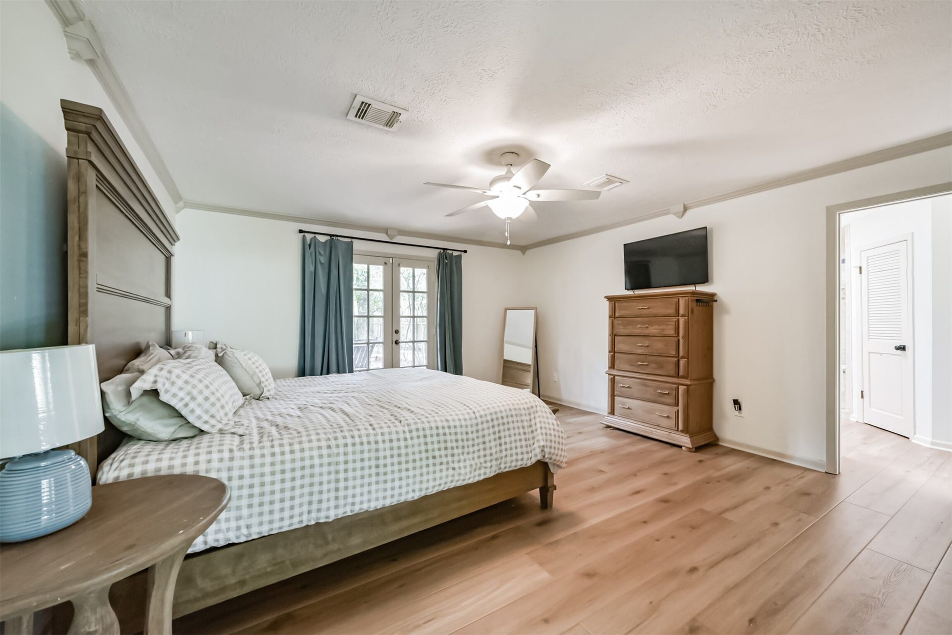 7618 Hurst Forest Drive, Humble, TX 77346 Unwind in a spacious bedroom with room for a large bed and additional furnishings. Soft colors, natural light, and warm wood-look flooring create a restful setting, while crown molding adds a polished finishing touch.