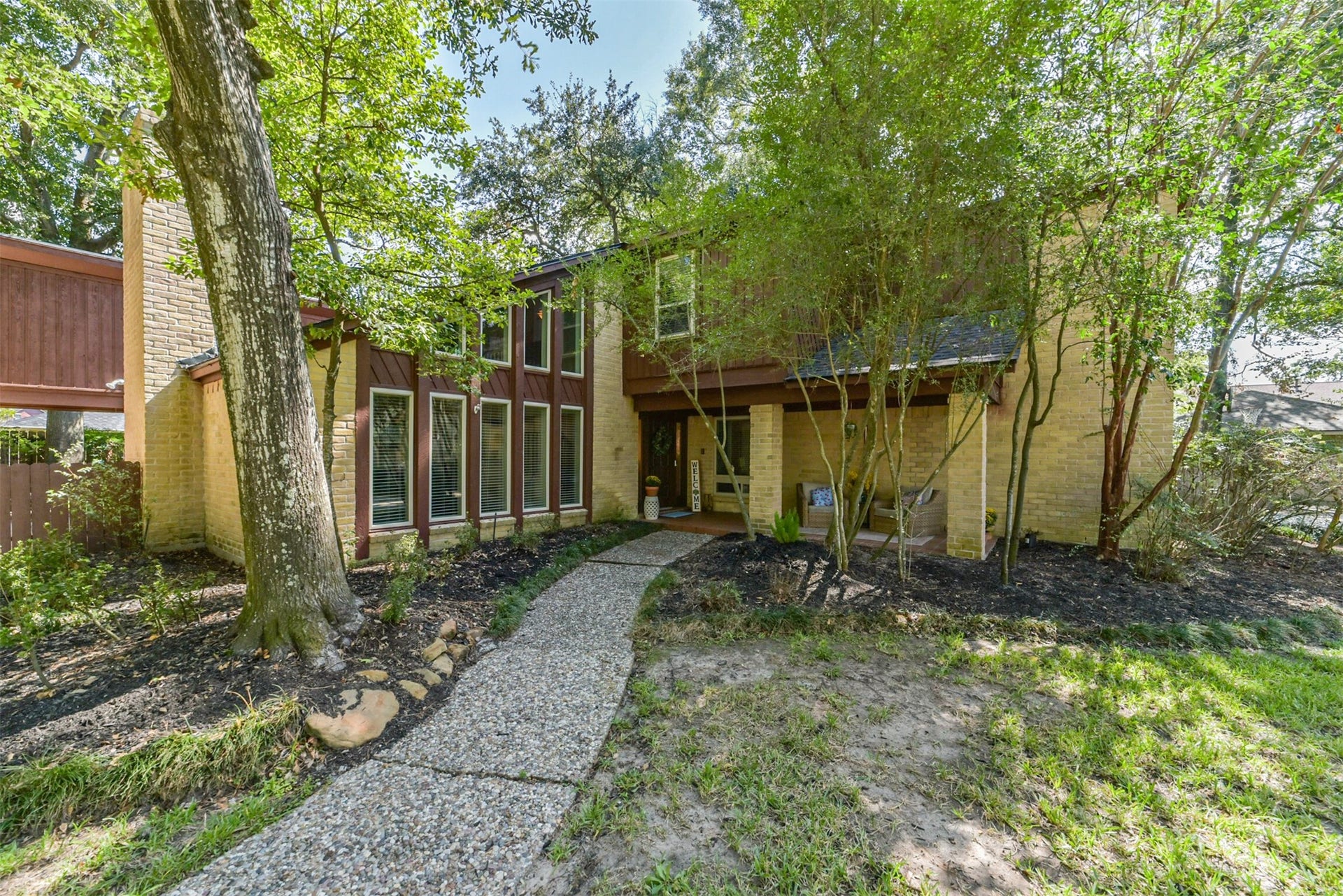 7618 Hurst Forest Drive, Humble, TX 77346 Follow the curved walkway through established landscaping to an entrance full of warmth and character. Tall windows and rich exterior textures create an inviting transition from the wooded yard to the home.