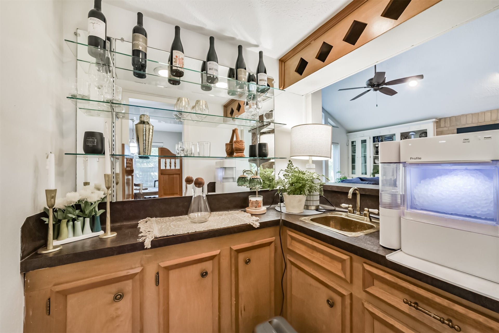 7618 Hurst Forest Drive, Humble, TX 77346 cccA dedicated wet bar adds a thoughtful touch for entertaining, with a sink, counter space, and cabinetry for serving essentials. Glass shelving and overhead bottle storage keep favorite beverages within reach of the adjoining living area.