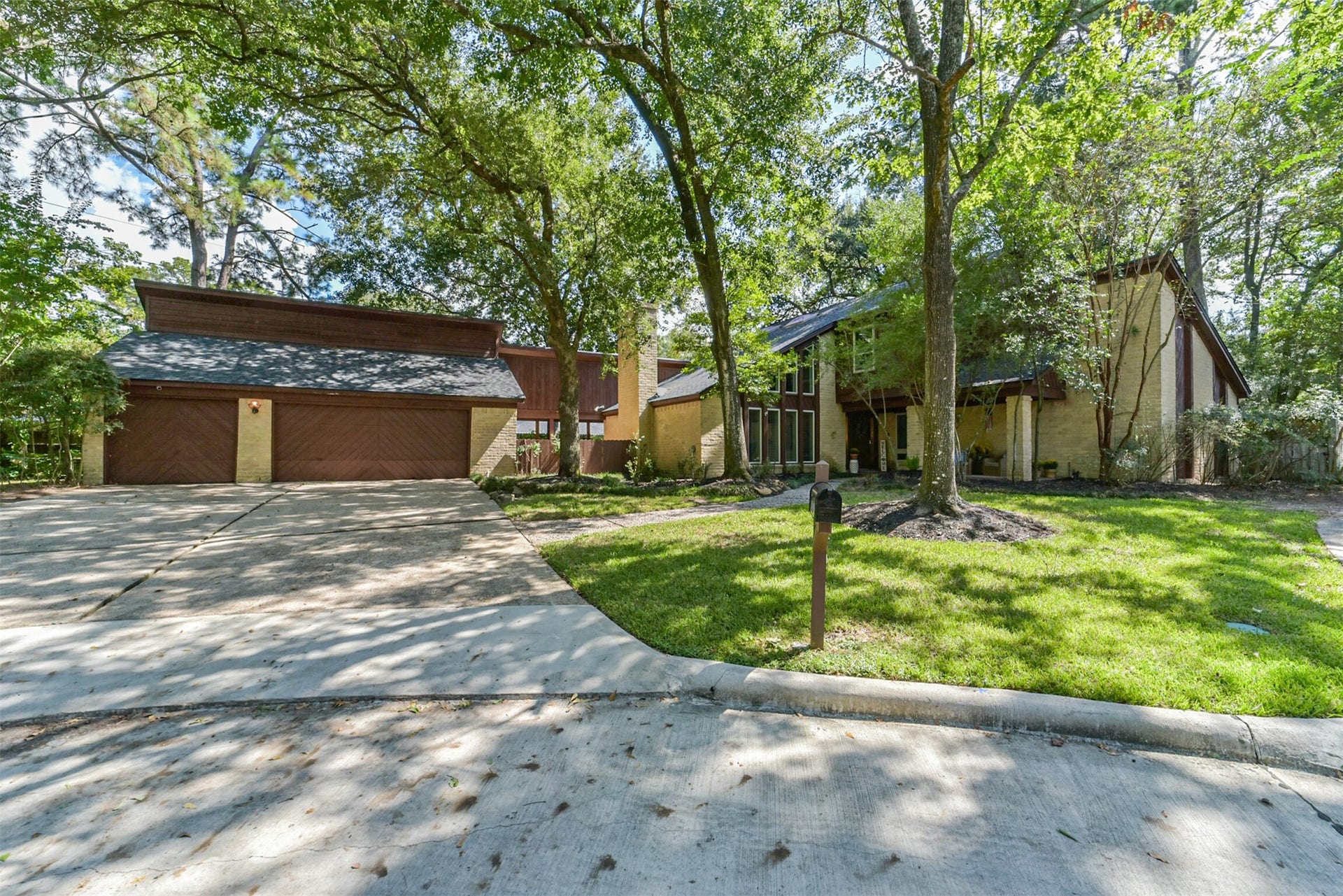 7618 Hurst Forest Drive, Humble, TX 77346 A sweeping driveway, green lawn, and mature shade trees give the front of the home an open, inviting feel. The generous approach adds everyday convenience while showcasing the homes charming architecture.