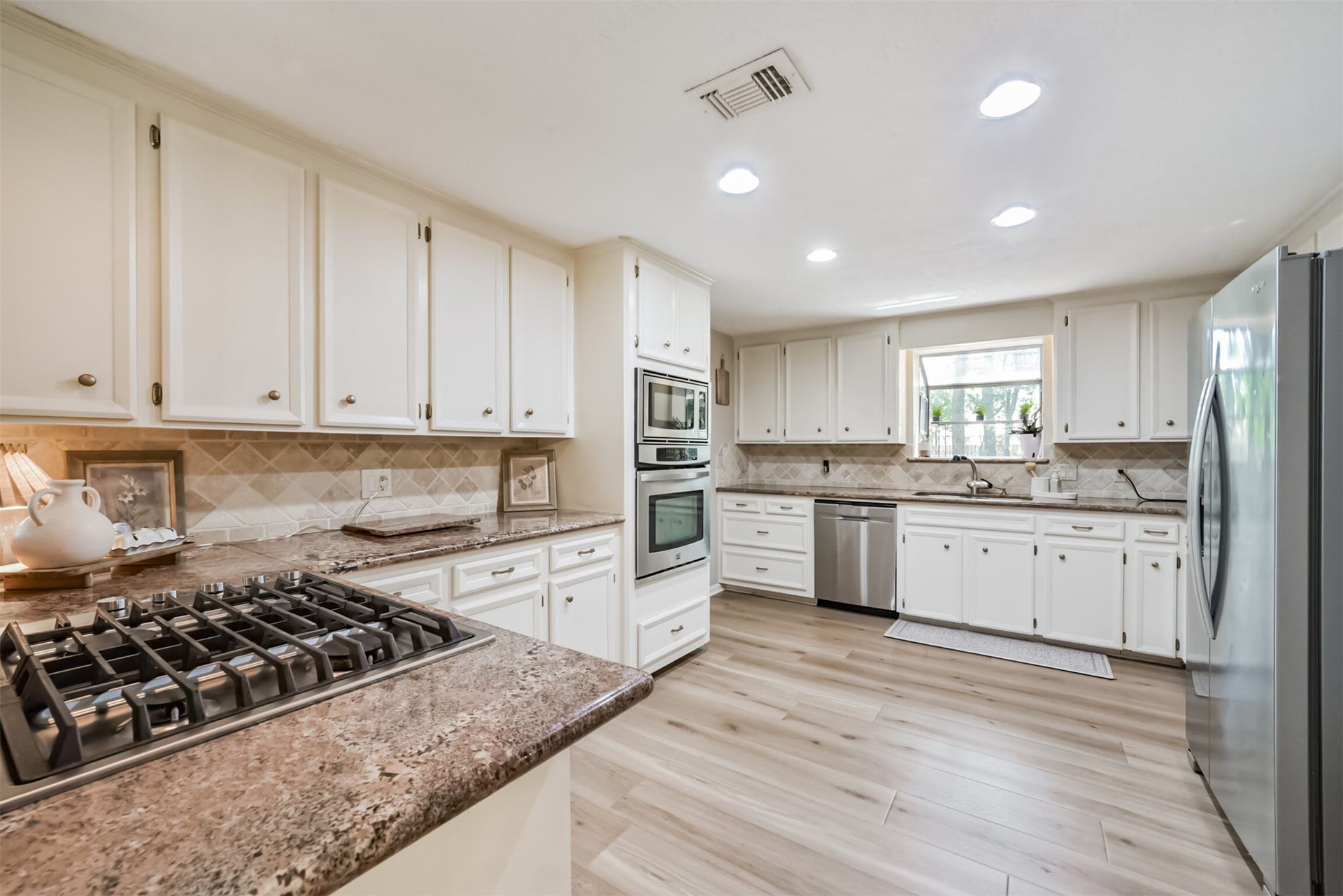 7618 Hurst Forest Drive, Humble, TX 77346 Bright cabinetry, generous counter space, and a gas cooktop make this kitchen an inviting place to prepare favorite meals. The spacious layout offers room to move comfortably, whether cooking dinner or hosting a weekend gathering.