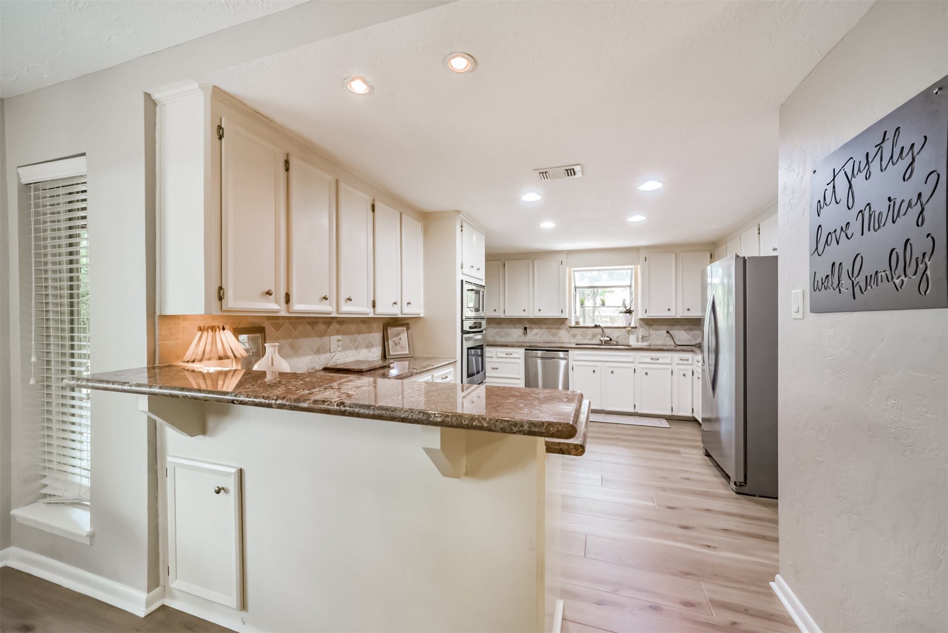 7618 Hurst Forest Drive, Humble, TX 77346 Ample cabinetry, generous counters, and a peninsula give the kitchen a practical layout for preparing and serving meals. The connection to the dining nook makes it easy to stay part of the conversation while cooking.