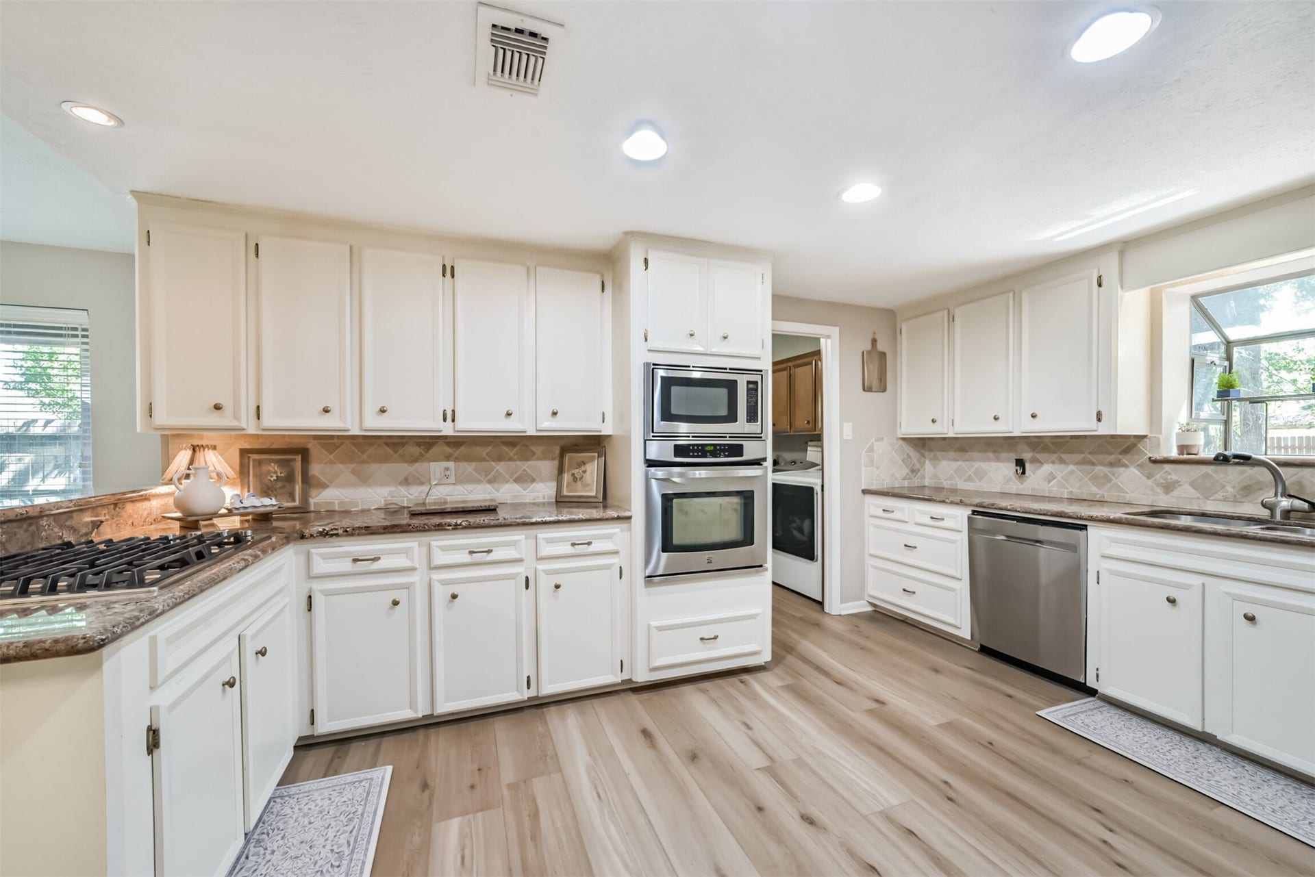 7618 Hurst Forest Drive, Humble, TX 77346 Wraparound counters and abundant cabinets keep cooking essentials close at hand while providing ample workspace. Recessed lighting and a window above the sink give the kitchen a bright, welcoming feel.