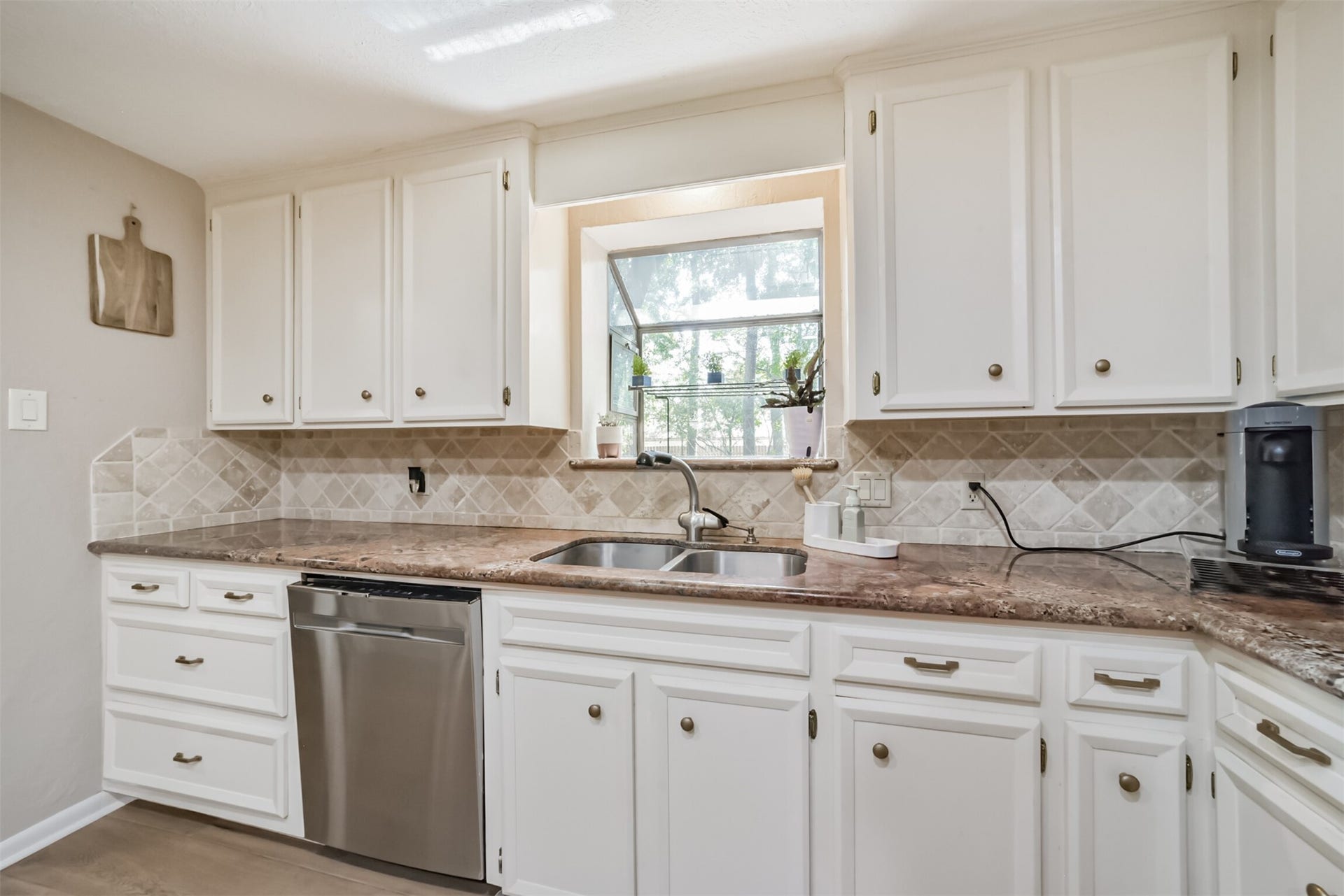 7618 Hurst Forest Drive, Humble, TX 77346 Enjoy a view of the greenery while tending to everyday kitchen tasks at the window-facing sink. Nearby counter space, cabinet storage, and a conveniently placed dishwasher make preparation and cleanup easy.