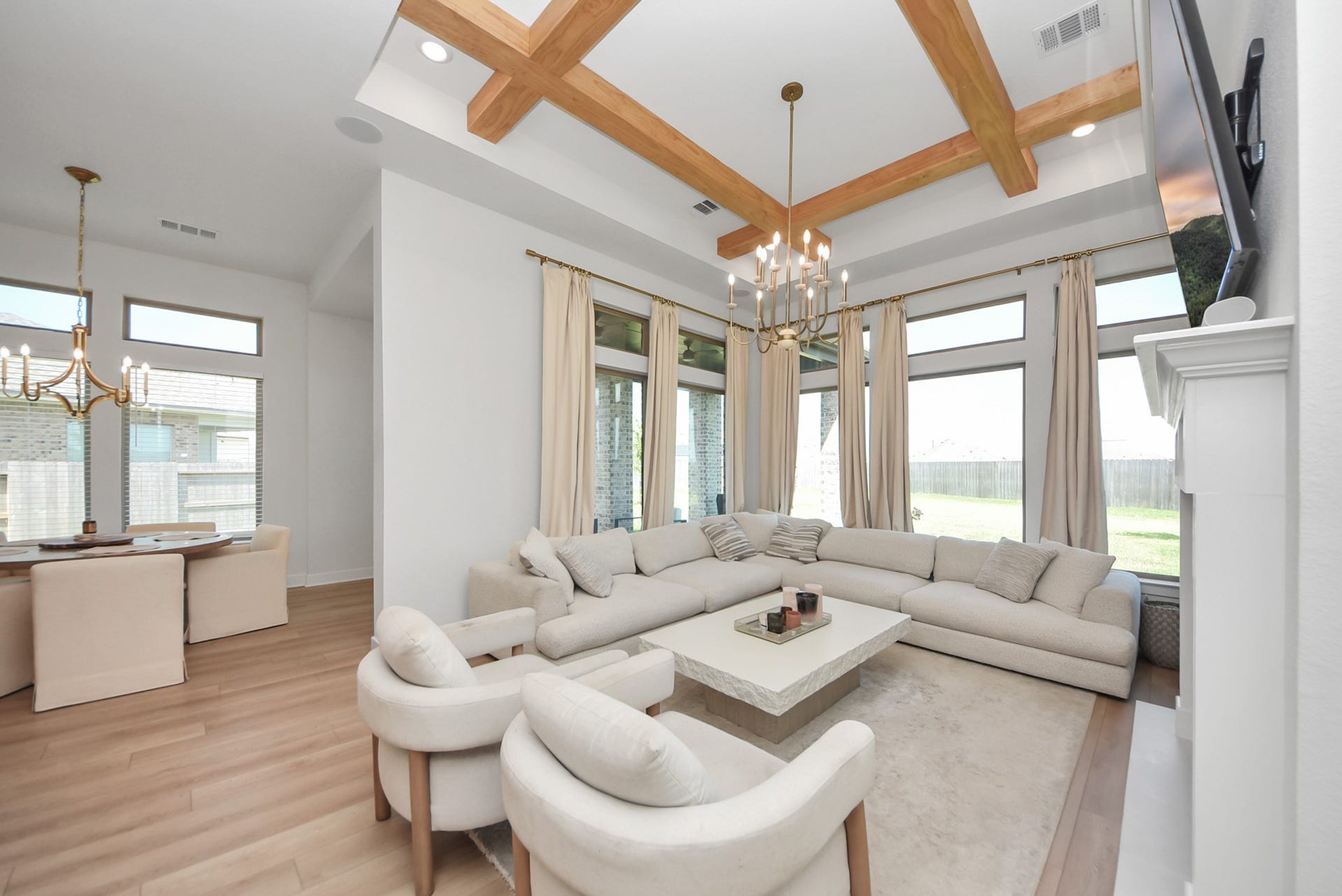 2995 Tantara Drive, Katy, TX 77493 Bright and inviting living room featuring a spacious sectional, elegant wood beam ceiling, and large windows offering abundant natural light.