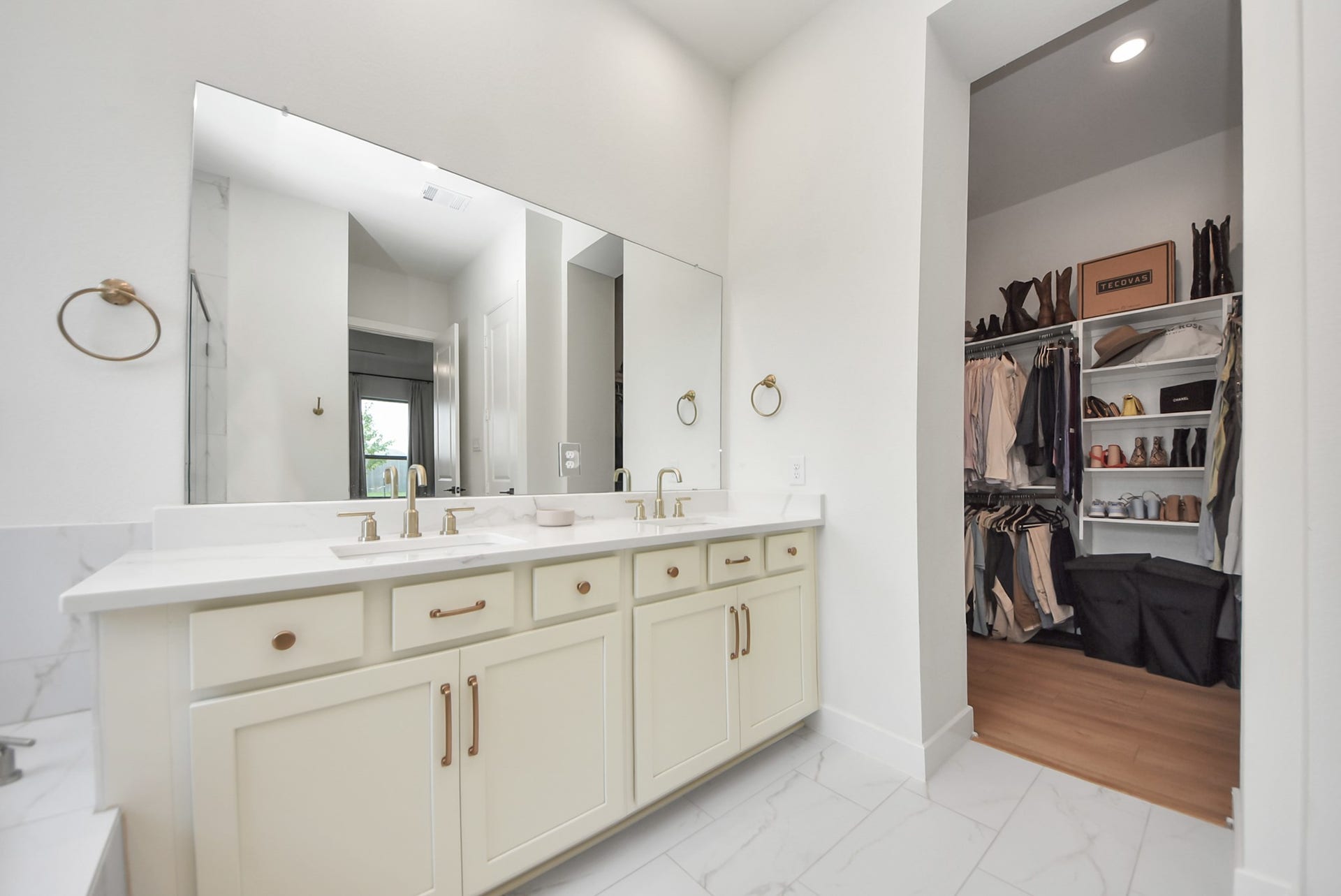 2995 Tantara Drive, Katy, TX 77493 Elegant bathroom featuring a dual-sink vanity with sleek fixtures and ample storage, seamlessly connected to a spacious walk-in closet.