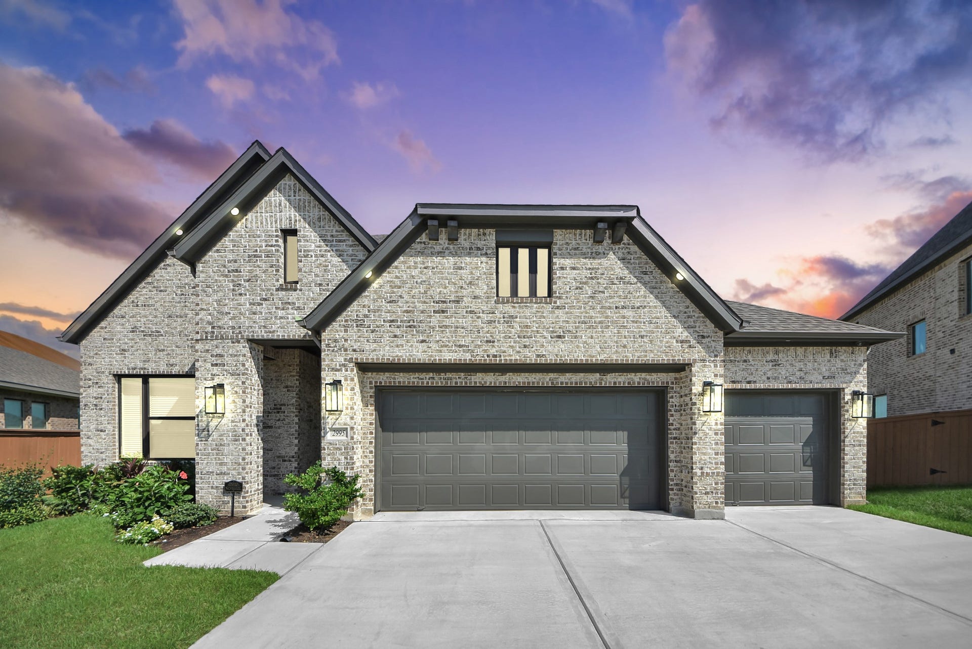 2995 Tantara Drive, Katy, TX 77493 Stunning brick home with a three-car garage, set against a vibrant sunset sky, offers a perfect blend of elegance and functionality.