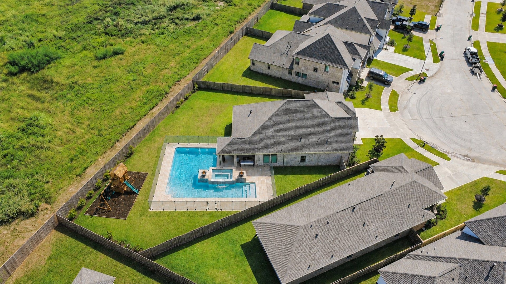 2995 Tantara Drive, Katy, TX 77493 Expansive backyard oasis featuring a sparkling pool and spa, surrounded by lush green lawn and a privacy fence, perfect for family gatherings and relaxation.