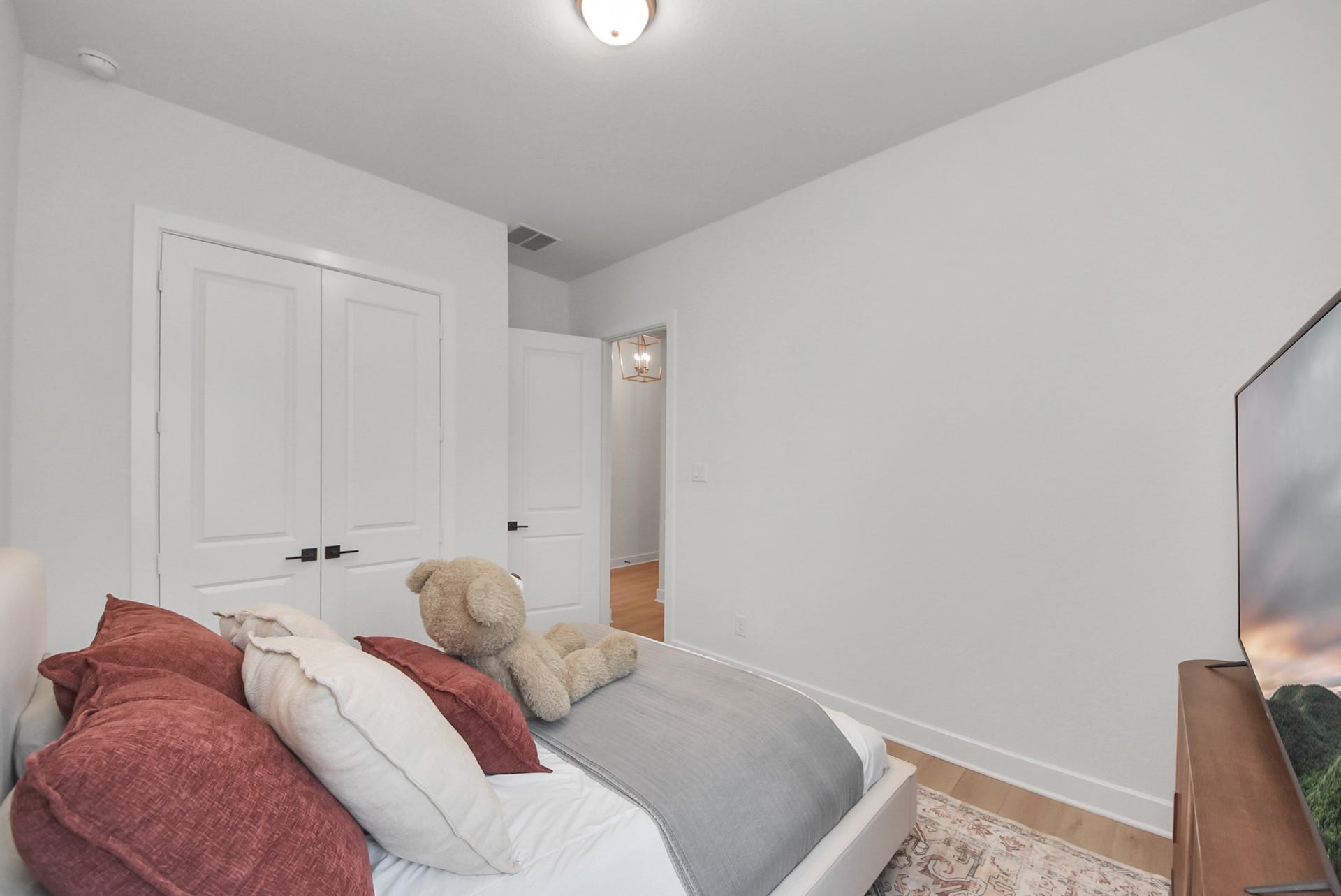 2995 Tantara Drive, Katy, TX 77493 Cozy bedroom with soft, neutral tones features a plush bed, ample closet space, and warm wood flooring, perfect for relaxation.
