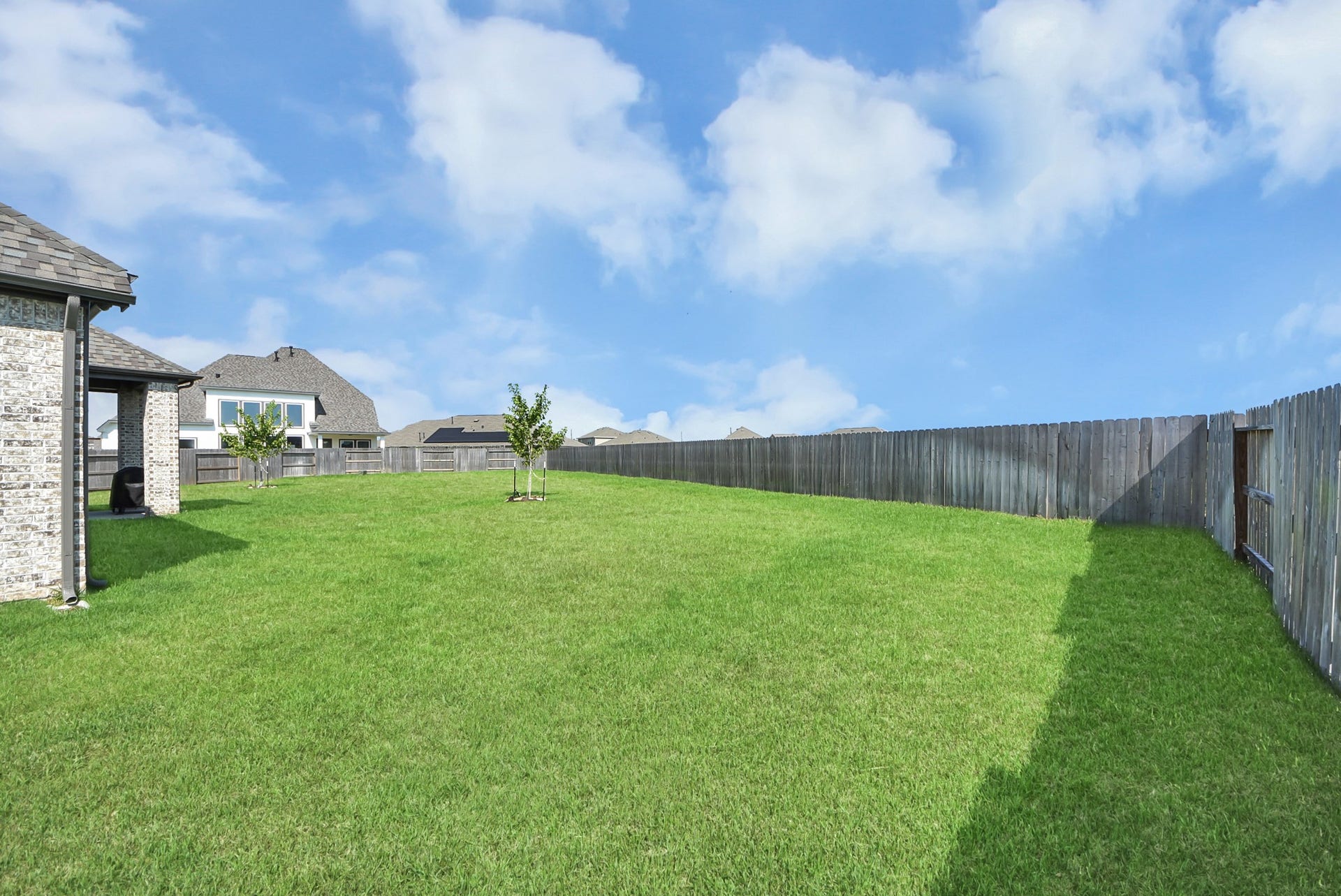 2995 Tantara Drive, Katy, TX 77493 Spacious fenced backyard with lush green lawn, perfect for outdoor activities and entertainment.