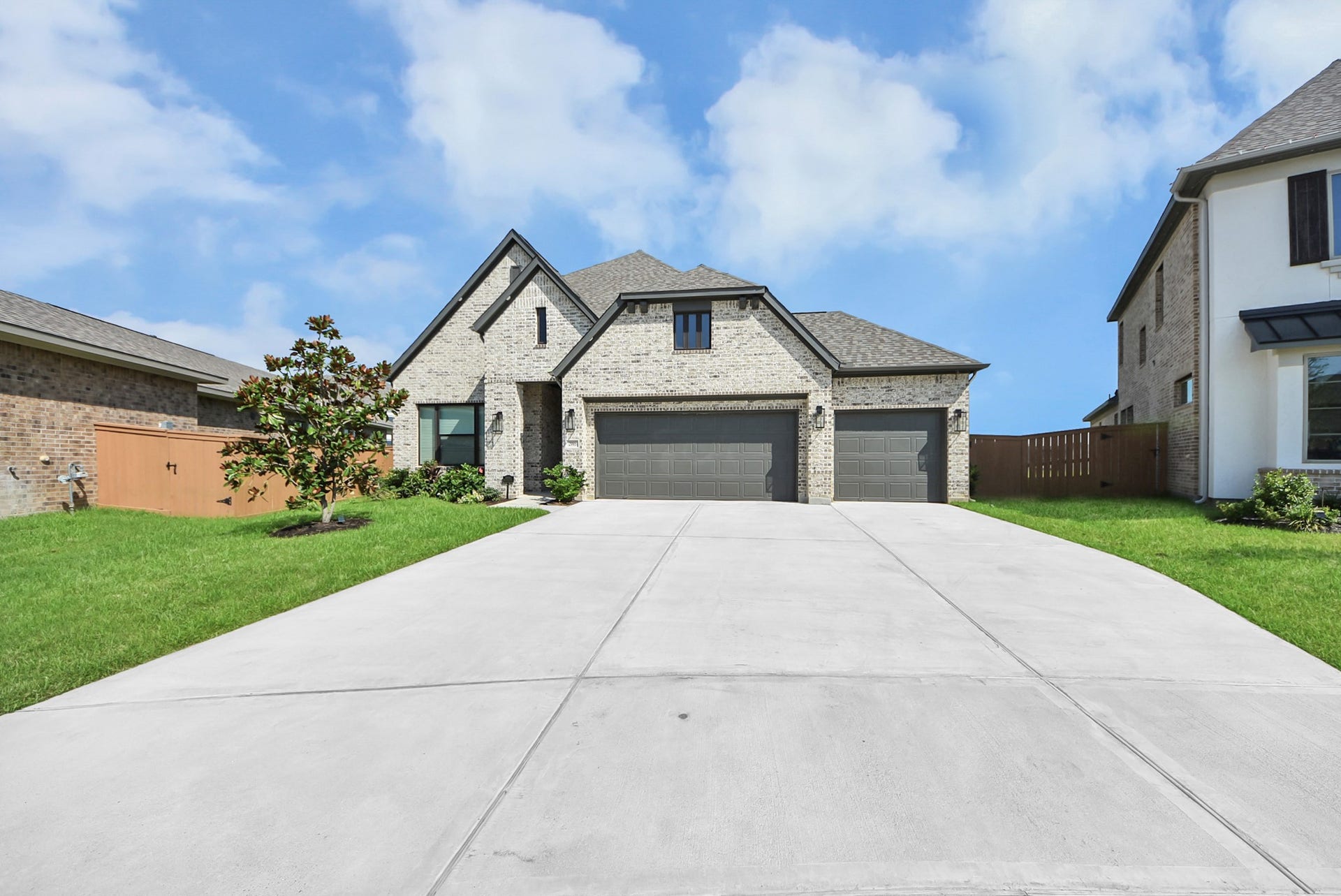2995 Tantara Drive, Katy, TX 77493 Stunning brick home with a spacious three-car garage, nestled in a well-maintained neighborhood, features lush green lawns and a wide driveway.