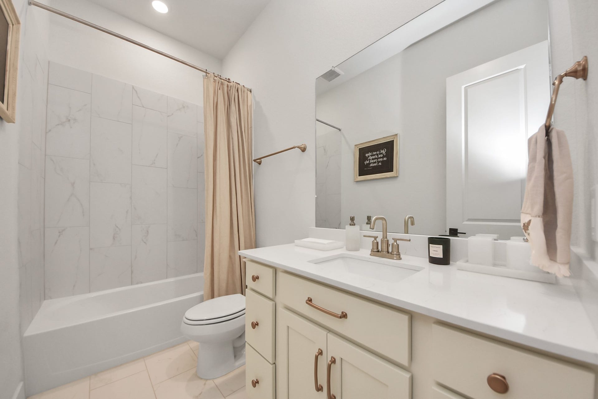 2995 Tantara Drive, Katy, TX 77493 Elegant bathroom with a sleek marble-tiled shower, stylish vanity with brass fixtures, and ample lighting for a bright, inviting atmosphere.