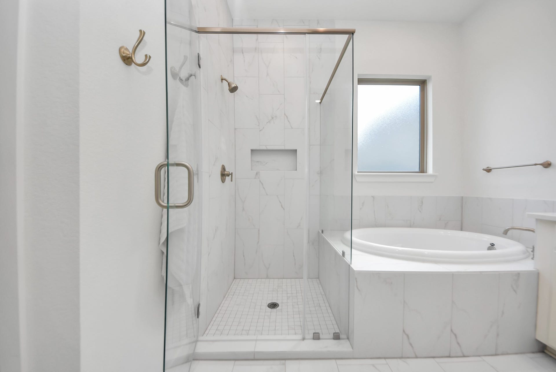 2995 Tantara Drive, Katy, TX 77493 Elegant bathroom featuring a luxurious walk-in shower with glass enclosure and a relaxing soaking tub, accented by stylish marble tiles.