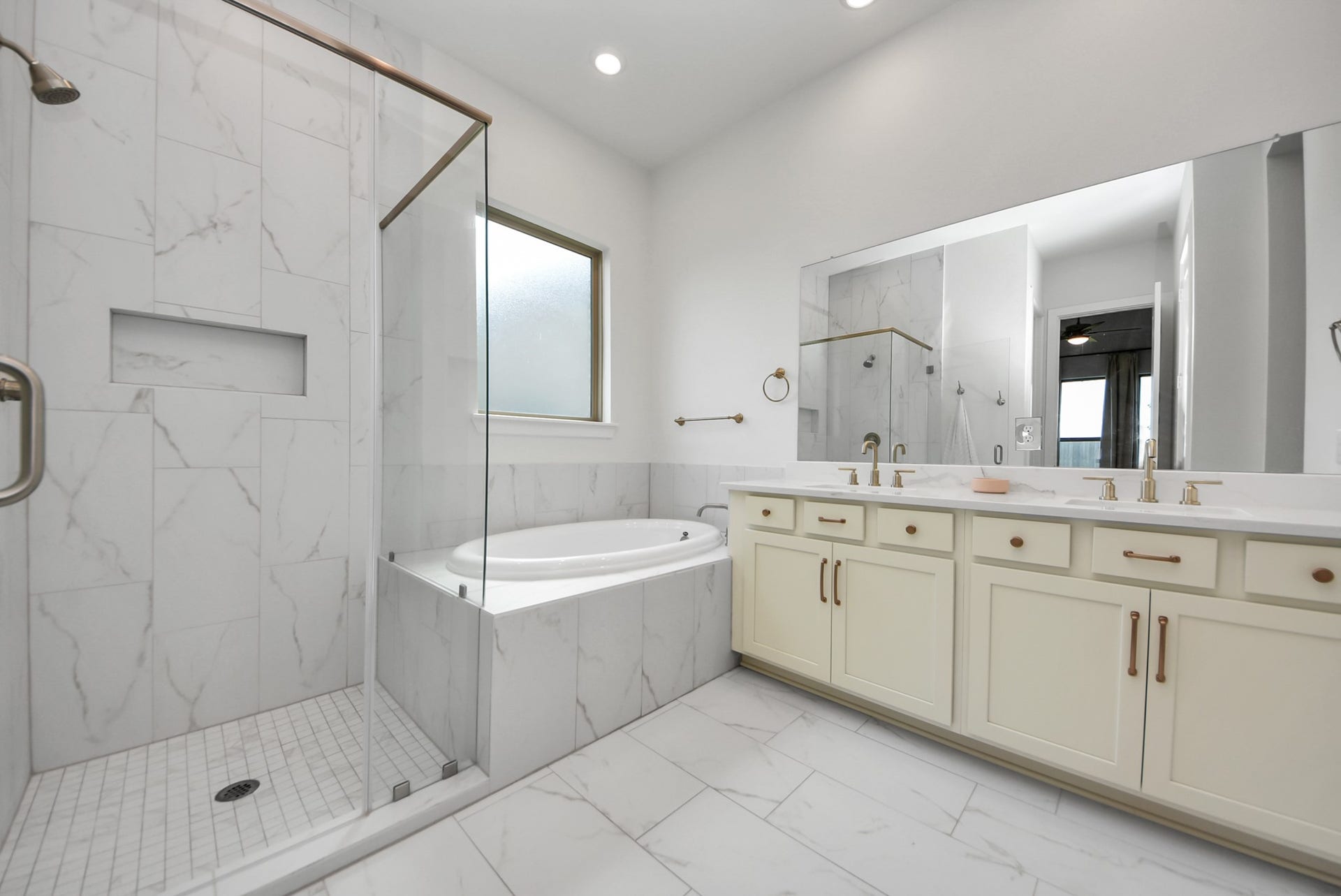 2995 Tantara Drive, Katy, TX 77493 Elegant bathroom featuring a spacious glass-enclosed shower, luxurious soaking tub, and dual-sink vanity with ample storage.