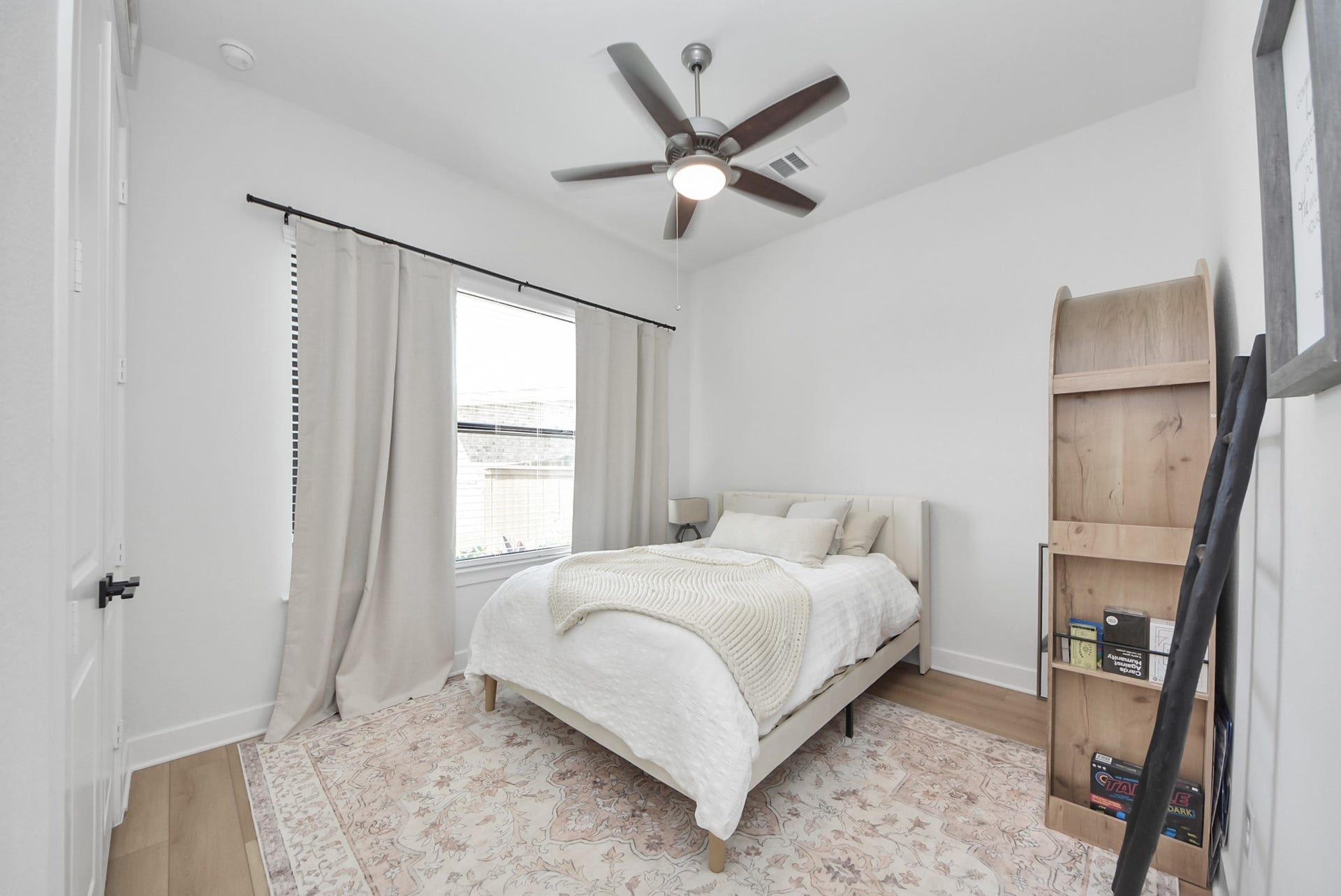 2995 Tantara Drive, Katy, TX 77493 Bright and cozy bedroom featuring a ceiling fan, large window with elegant drapes, and a warm, neutral color palette.