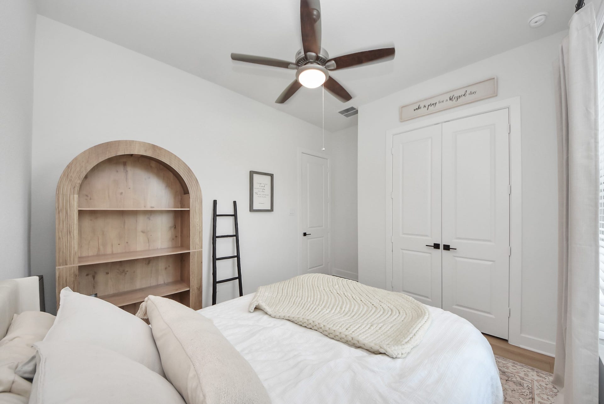 2995 Tantara Drive, Katy, TX 77493 Cozy bedroom with a stylish ceiling fan, built-in shelving, and a double closet, offering ample storage and a modern touch.