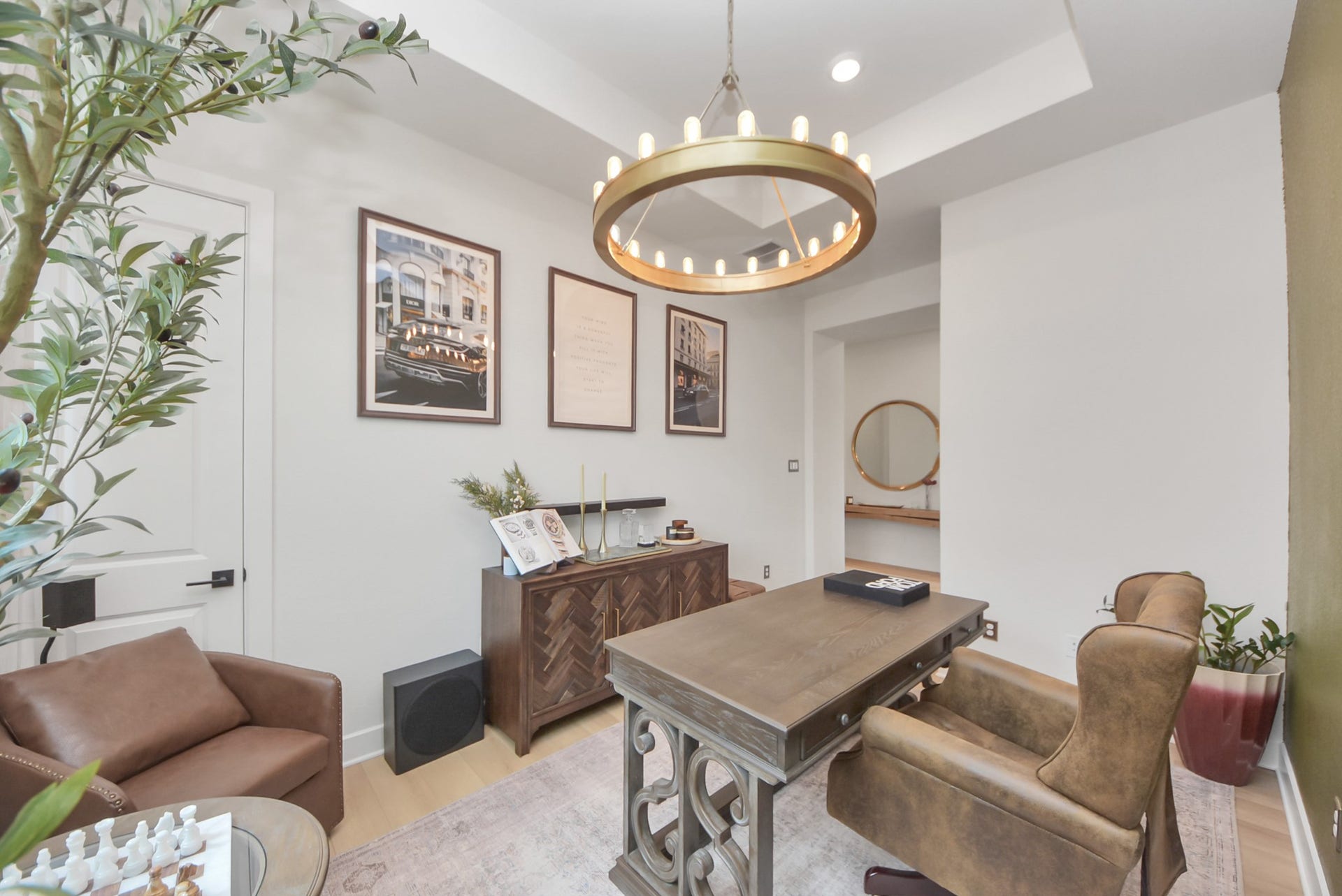 2995 Tantara Drive, Katy, TX 77493 Elegant home office with stylish decor, featuring a sophisticated wooden desk and comfortable leather seating. The space is enhanced by a modern chandelier and tasteful artwork, creating a refined ambiance for productivity.
