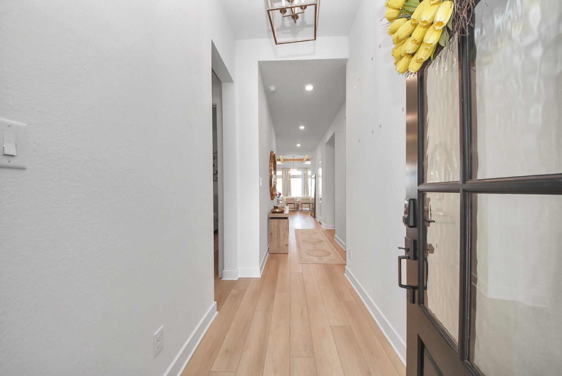 2995 Tantara Drive, Katy, TX 77493 Step into a bright and welcoming entryway featuring elegant wood flooring and modern lighting, leading into an inviting open-concept living area.