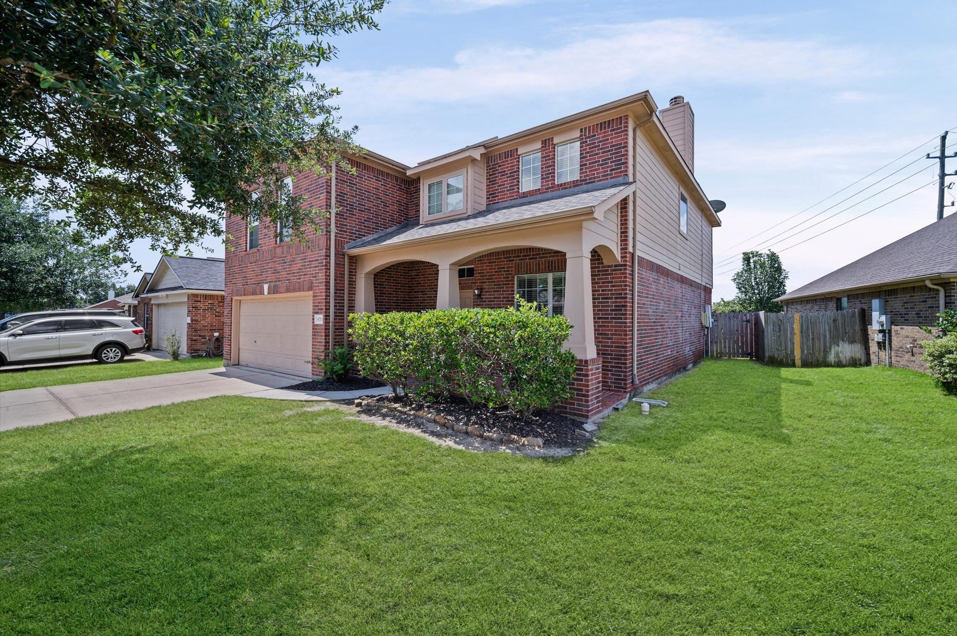 8711 Sandusky Court, Tomball, TX 77375 This is a two-story brick home with a well-maintained lawn, a one-car garage, and a covered front porch. It features a driveway and is situated in a suburban neighborhood.