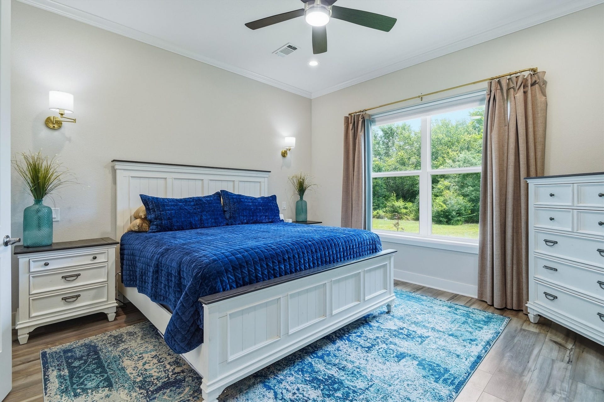 6115 San Leon Drive, Dickinson, TX 77539 Primary bedroom with sconces, ceiling fan and double window overlooking the property