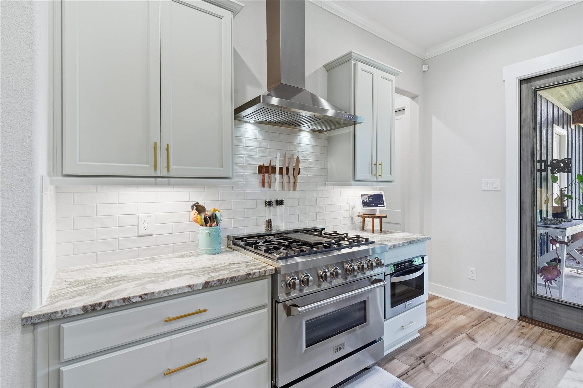 6115 San Leon Drive, Dickinson, TX 77539 Stainless steel vent hood, gas range and microwave drawer. Shaker style cabinetry, useful set of drawers, brushed brass hardware and under cabinet lighting illuminates workspace.