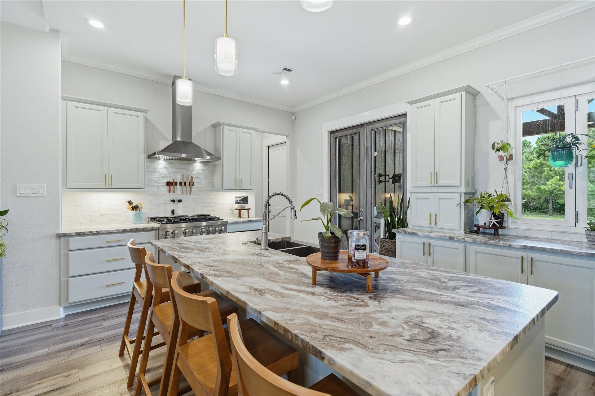 6115 San Leon Drive, Dickinson, TX 77539 Large central island featuring leathered granite and pendant lighting. Stainless steel hood vent plus 6 burner range cooktop. Accordion style windows open to patio.