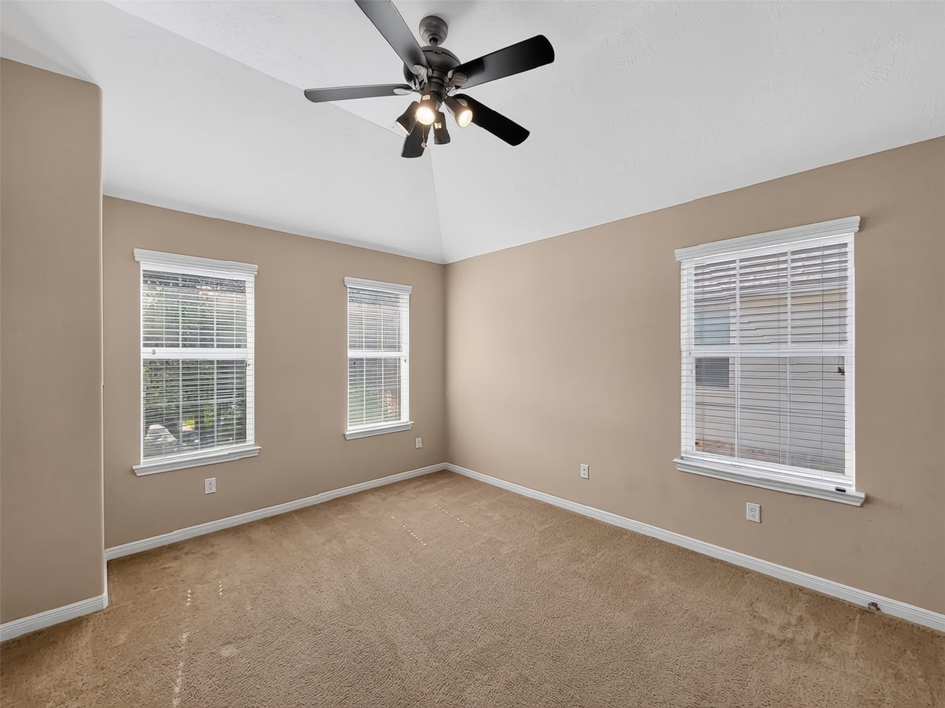 2006 Linden Cove Court, Katy, TX 77494 Spacious and bright room with neutral walls, plush carpet, and a ceiling fan, featuring three large windows for ample natural light.