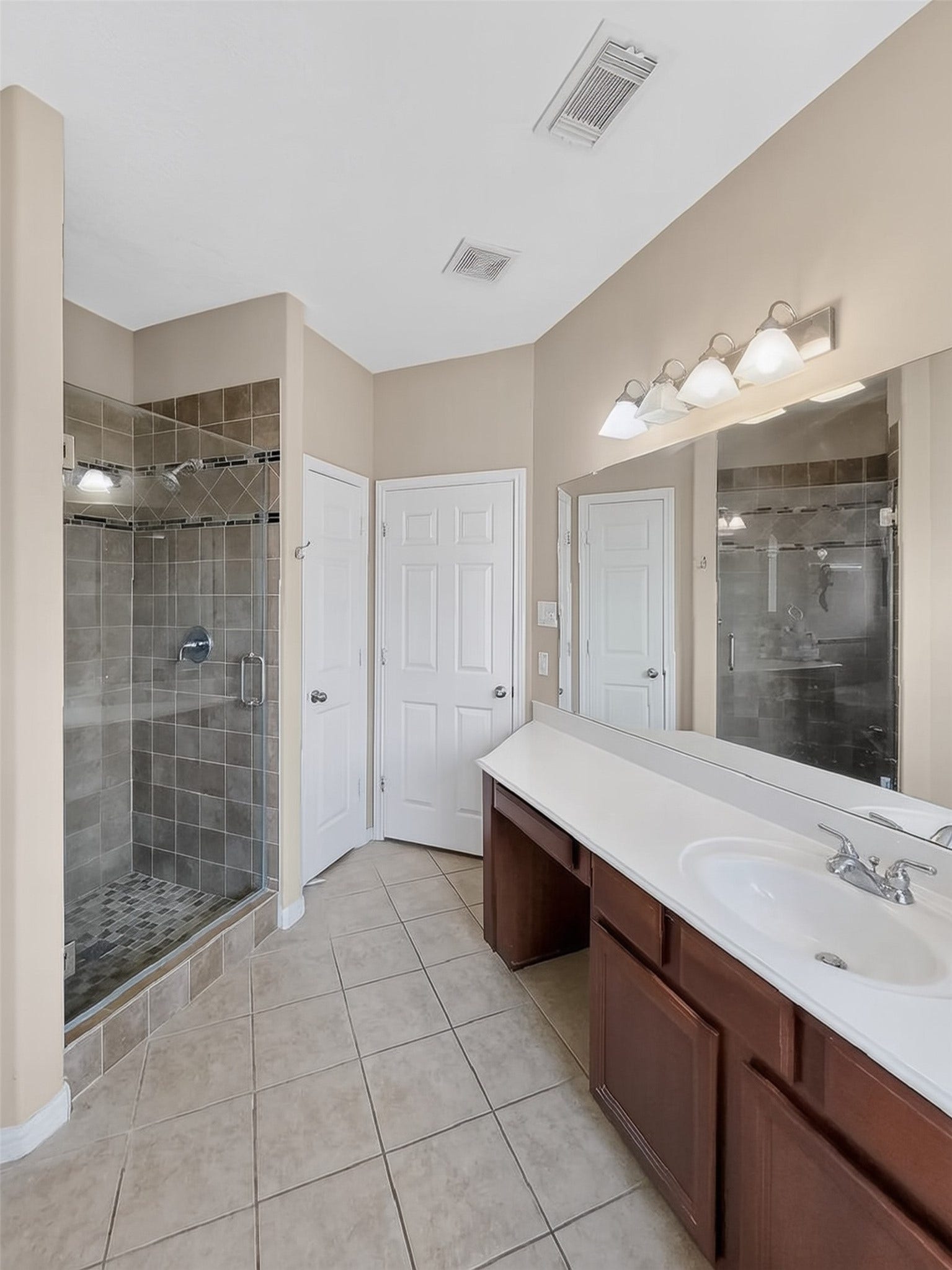 2006 Linden Cove Court, Katy, TX 77494 Spacious bathroom featuring a large walk-in shower with sleek glass doors, dual vanity with ample counter space, and elegant tile flooring.