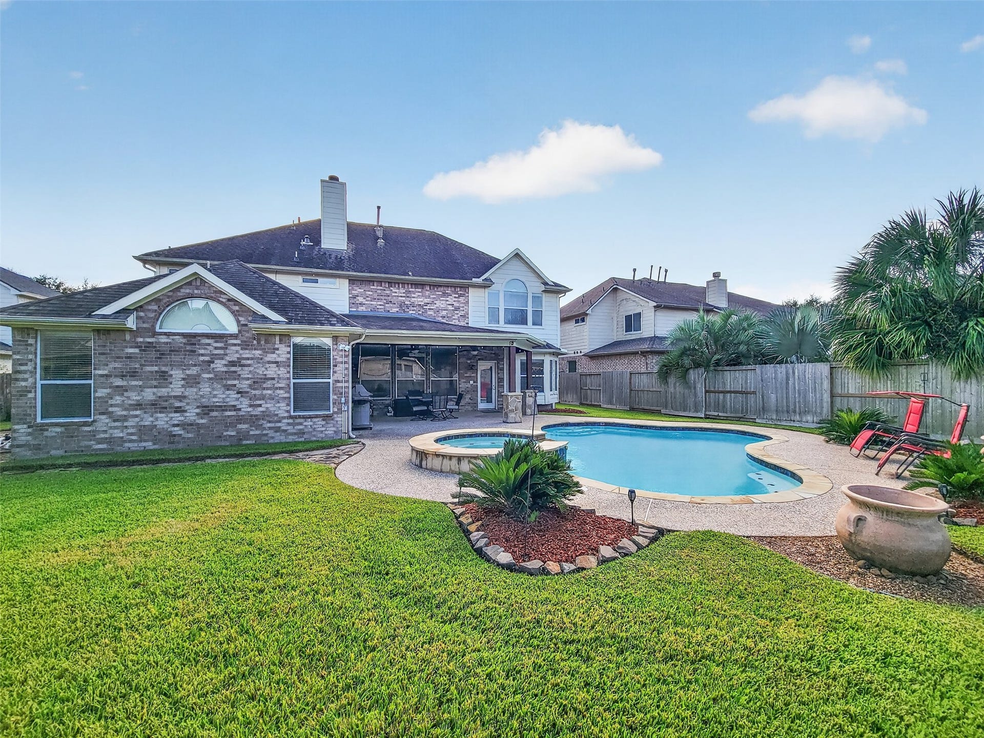 2006 Linden Cove Court, Katy, TX 77494 Charming two-story brick home with a spacious backyard featuring a sparkling pool, lush landscaping, and a covered patio perfect for entertaining.