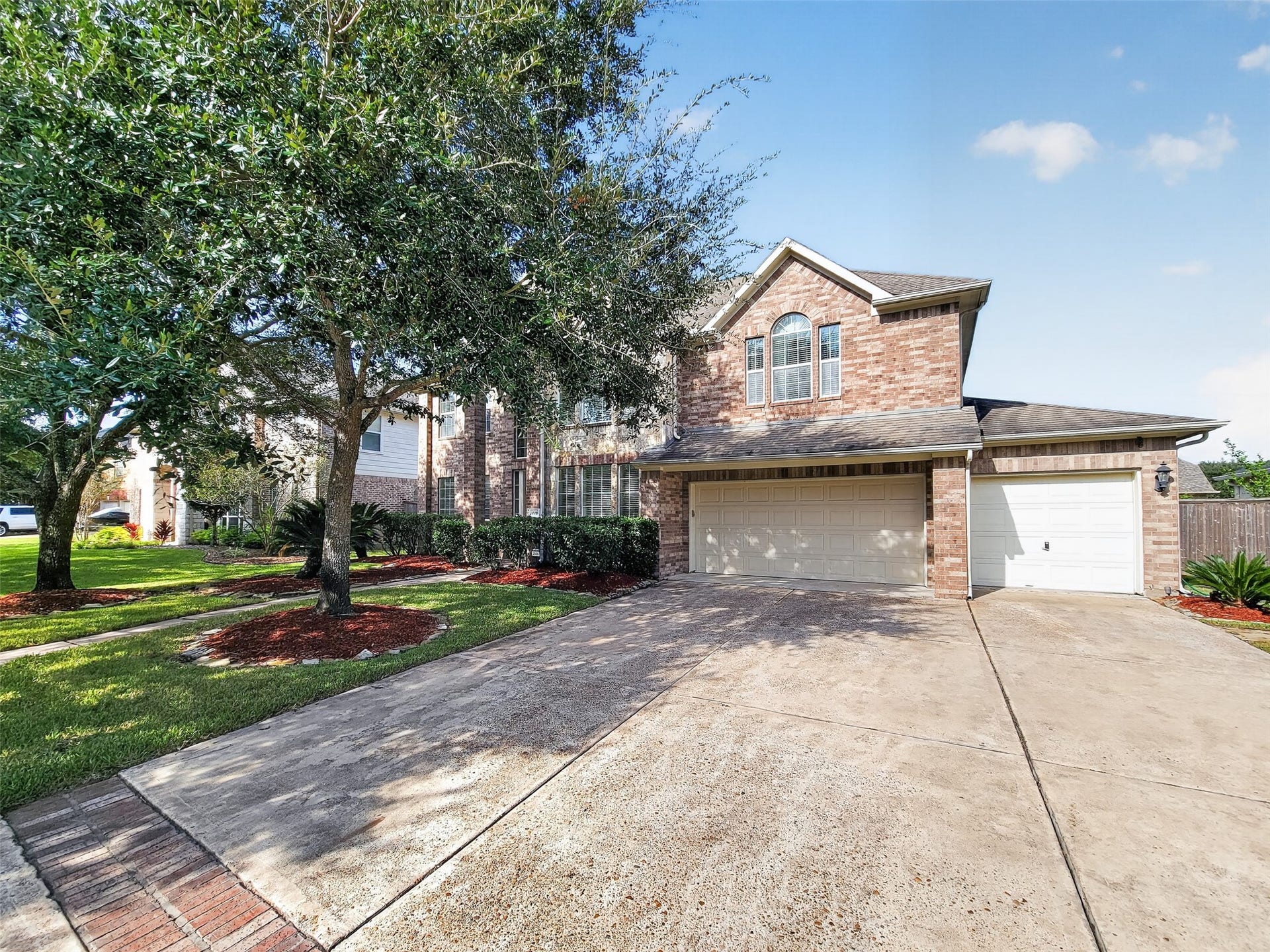 2006 Linden Cove Court, Katy, TX 77494 Stately two-story brick home with a spacious three-car garage, nestled among mature trees and lush landscaping.