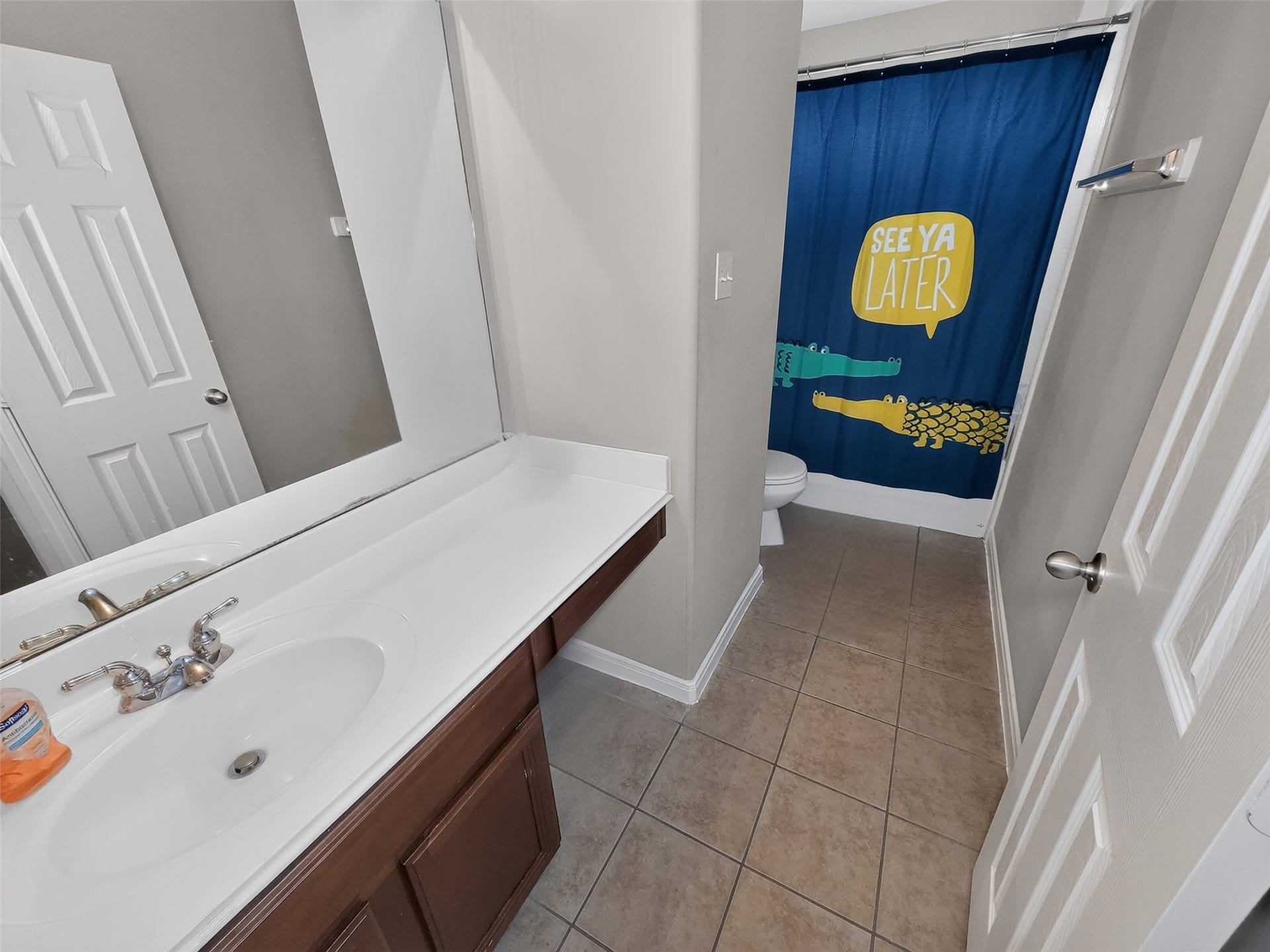 2006 Linden Cove Court, Katy, TX 77494 Charming bathroom featuring a large vanity, modern fixtures, and playful shower curtain, offering a cozy and functional space.